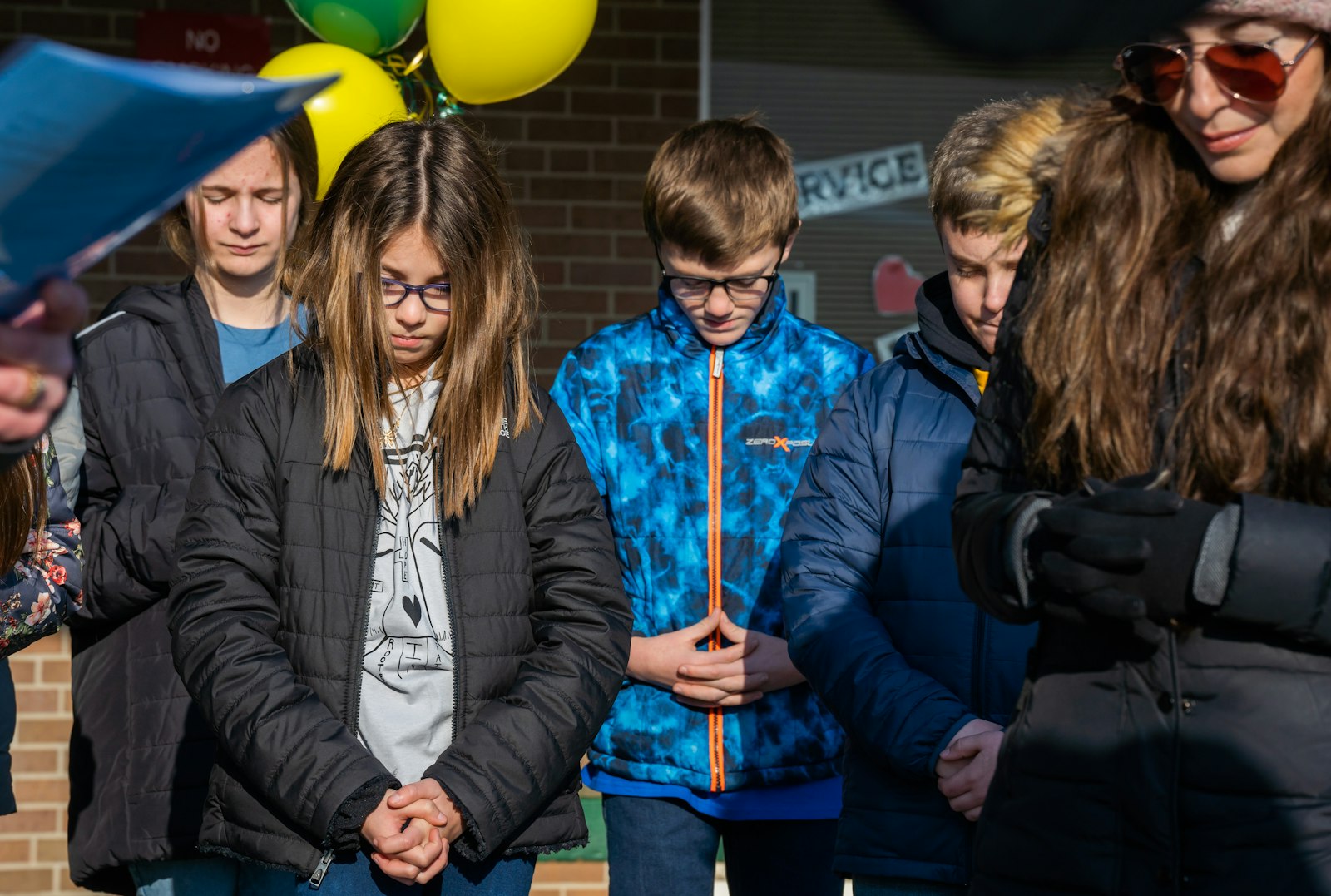 St. Charles Academy students bow their heads in prayer during a Catholic Schools Week broadcast Jan. 31.