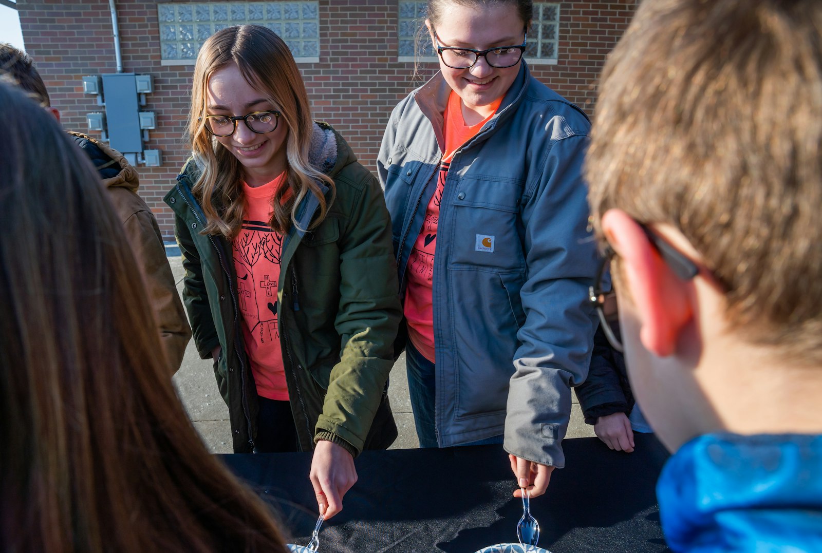 St. Charles Academy students play a game trying to transfer Skittles via a spoon during a live broadcast at the school on Jan. 31, the first day of Catholic Schools Week.