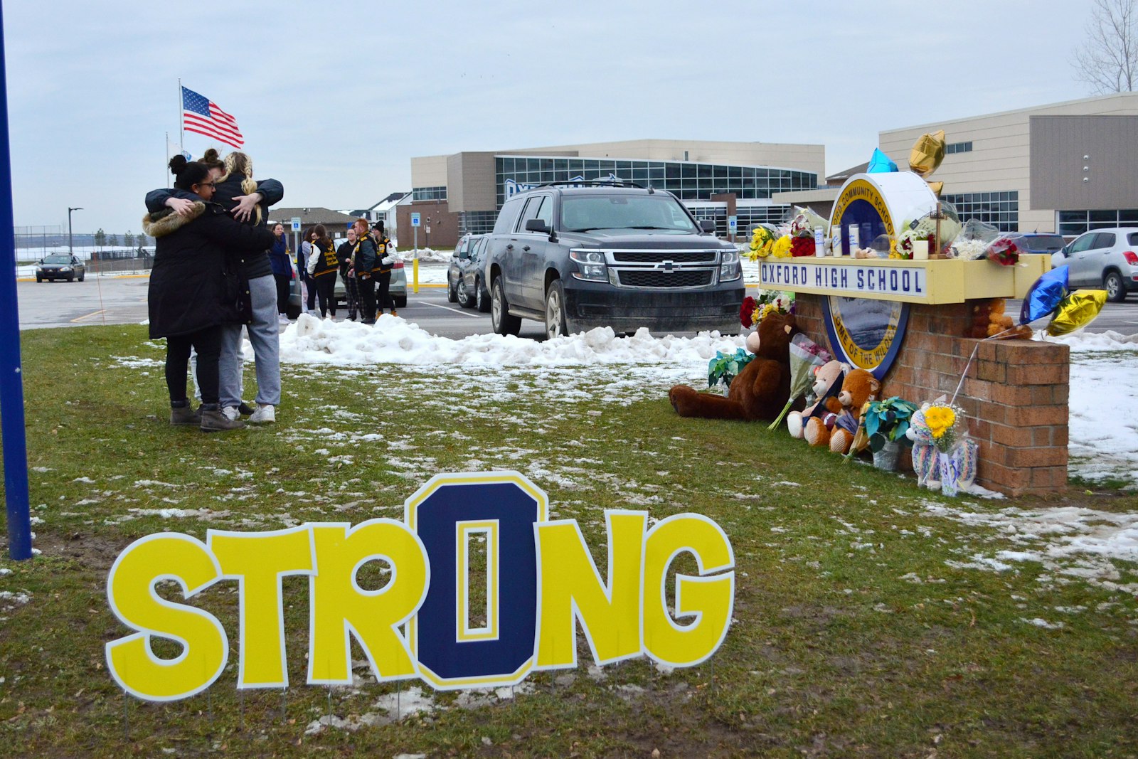 Students embrace one another outside Oxford High School on Dec. 1 as authorities continued the investigation. Across Oxford and neighboring Lake Orion, community members posted signs of support and continued their prayers for the victims.