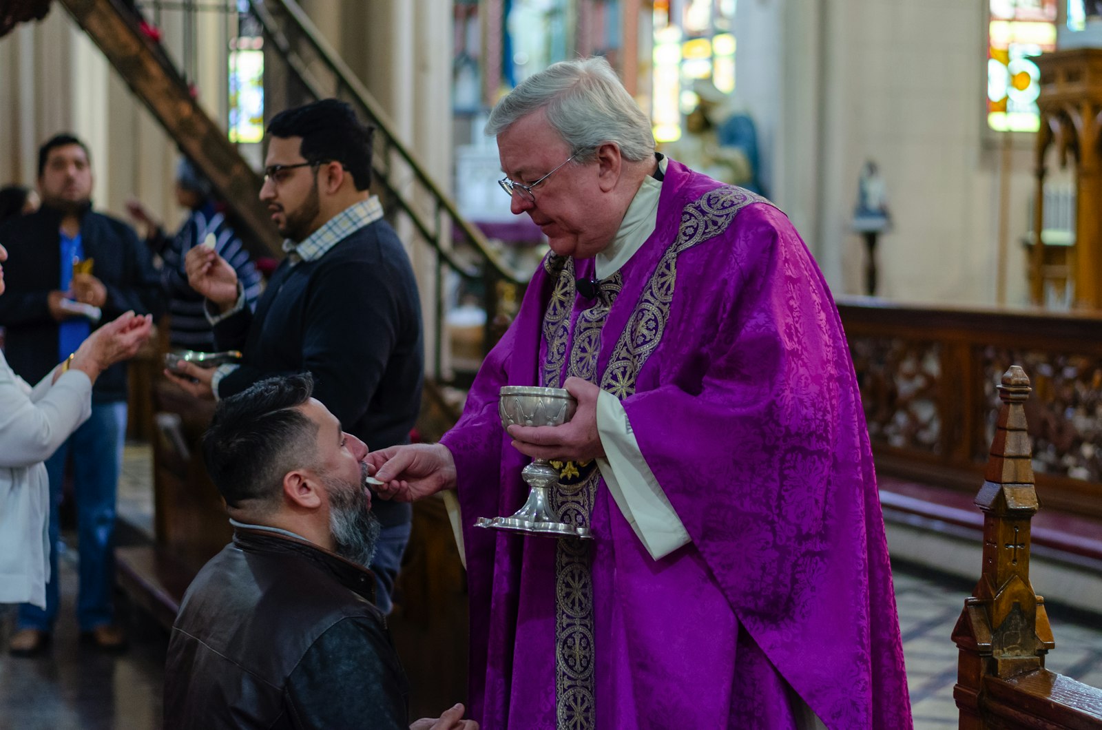 Msgr. Charles Kosanke, rector of the Basilica of Ste. Anne, offers Communion to a parishioner during a Mass at the basilica. Msgr. Kosanke announced the parish's partnership with The Catholic Initiative during Masses the weekend of March 9. (Photo by Matthew Rich | Special to Detroit Catholic)