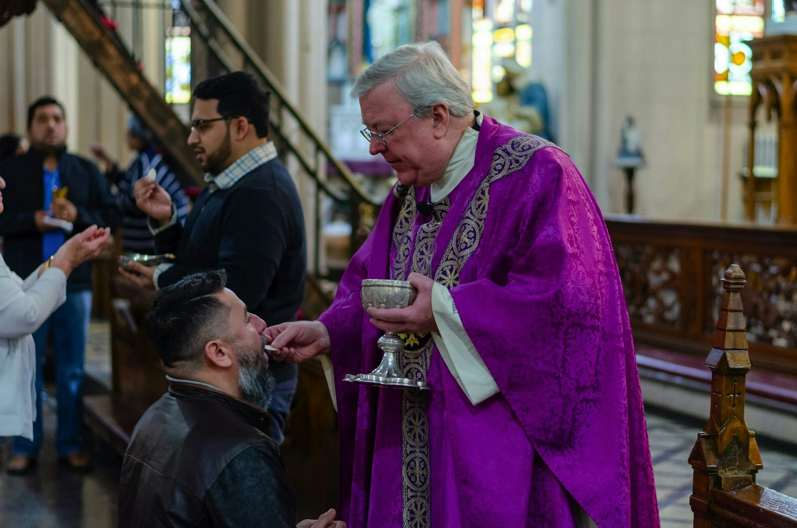 Msgr. Charles Kosanke, rector de la Basilica of Ste. Anne, ofrece la Comunión a un feligrés durante una misa en la basílica. Mons. Kosanke anunció la alianza de la parroquia con The Catholic Initiative durante las misas del fin de semana del 9 de marzo. (Foto de Matthew Rich | Especial para Detroit Catholic)