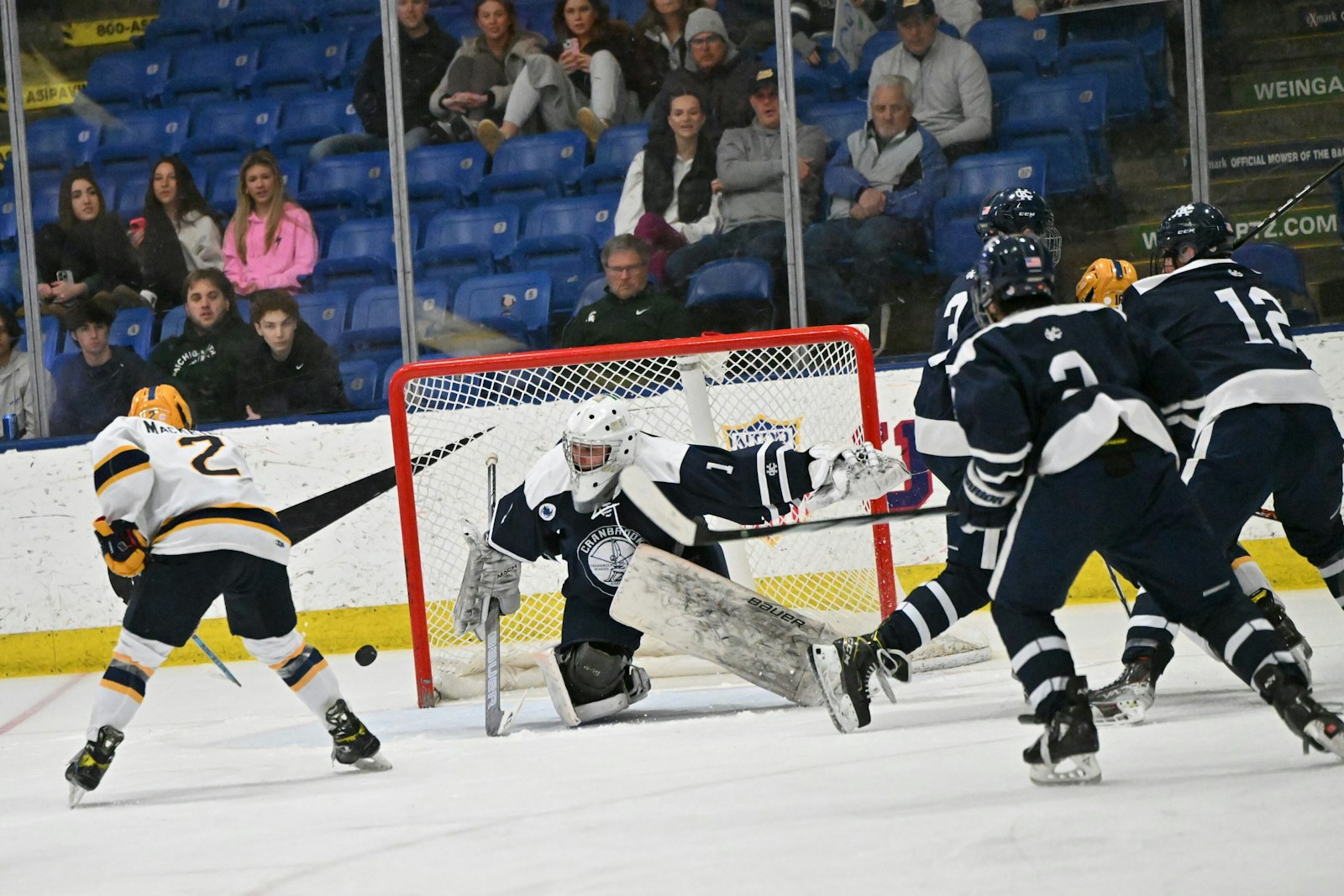 Bloomfield Hills Cranbrook goaltender Garrett Dudlar turns away a shot by East Grand Rapids’ Ian Mac Keigan – one of 53 saves Dudlar made all afternoon – helping Cranbrook win the Division 3 state hockey championship. (Photo courtesy of Hockey Weekly Action Photos)