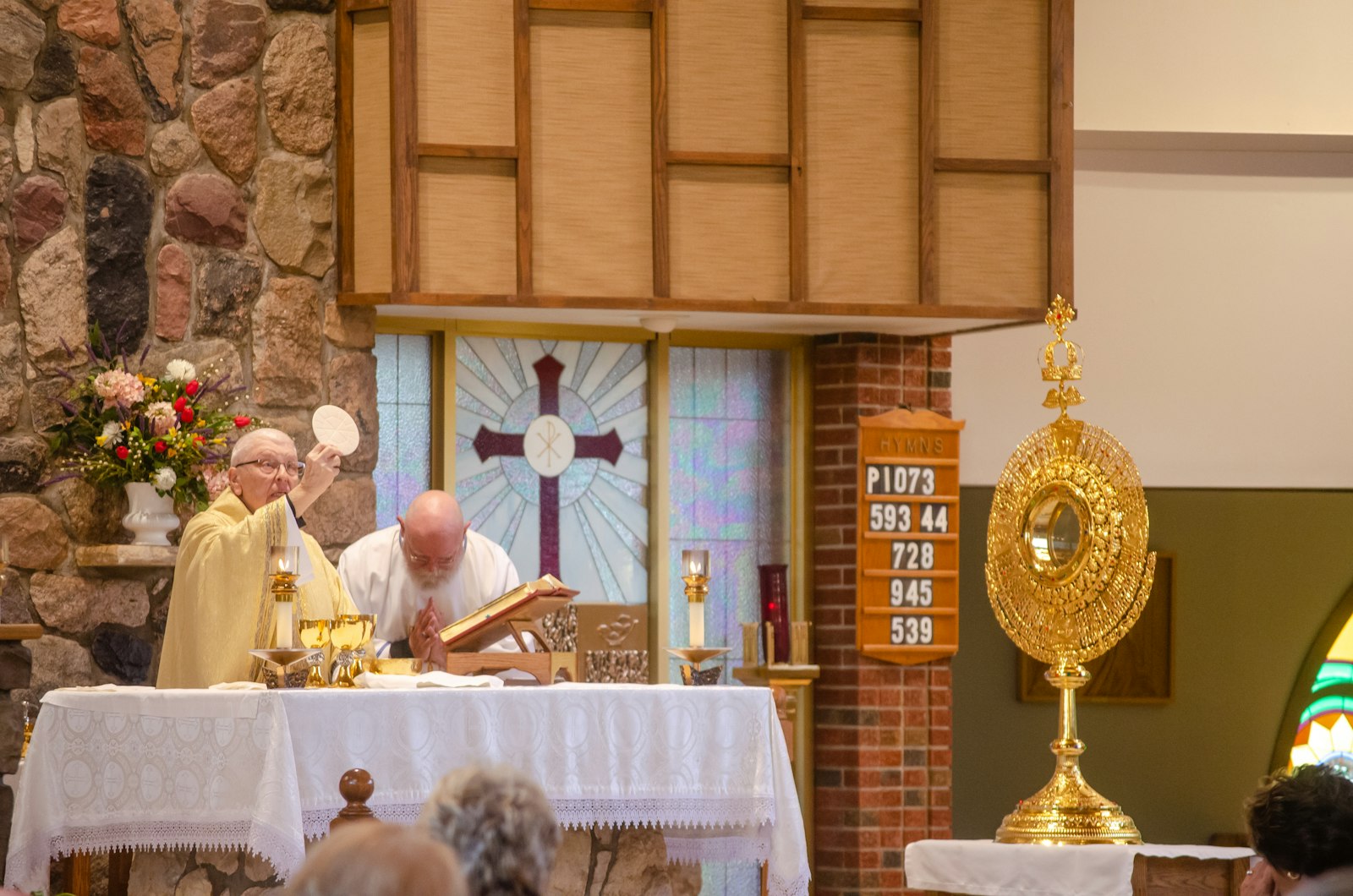 Fr. Rich Treml, pastor of SS. Peter and Paul Parish, consecrates the Eucharistic host during a Mass preceding the adoration at the rural northern Lapeer parish.