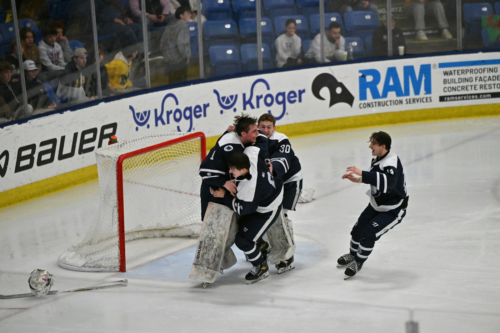 Cranbrook teammates rush back to get goaltender Garrett Dudlar (1) involved in the celebration after a sudden-death goal in triple-overtime gave the Cranes the Division 3 state championship over East Grand Rapids. (Photo courtesy of Hockey Weekly Action Photos)