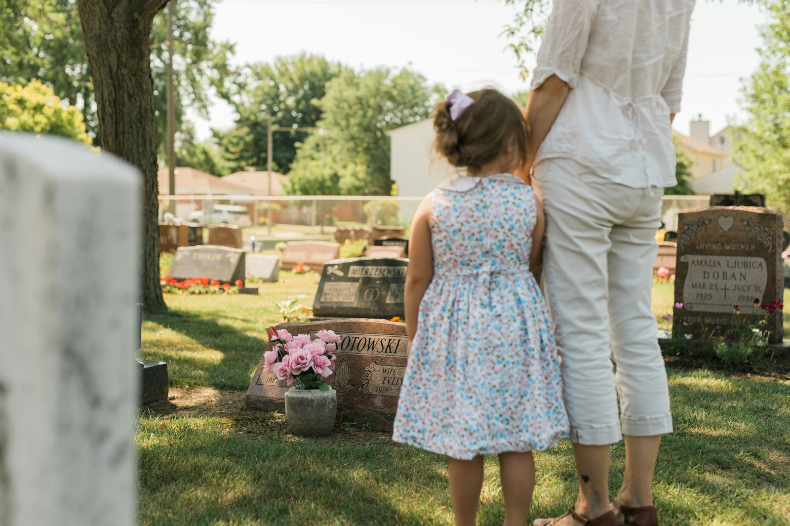 Una niña y su madre visitan la tumba de un ser querido en el cementerio Our Lady of Mt. Carmel en Wyandotte. En una nueva nota pastoral, el arzobispo Vigneron ofrece una catequesis sobre la enseñanza católica sobre el purgatorio, las indulgencias y la antigua práctica de orar por los muertos. (Melissa Moon | Detroit Catholic)