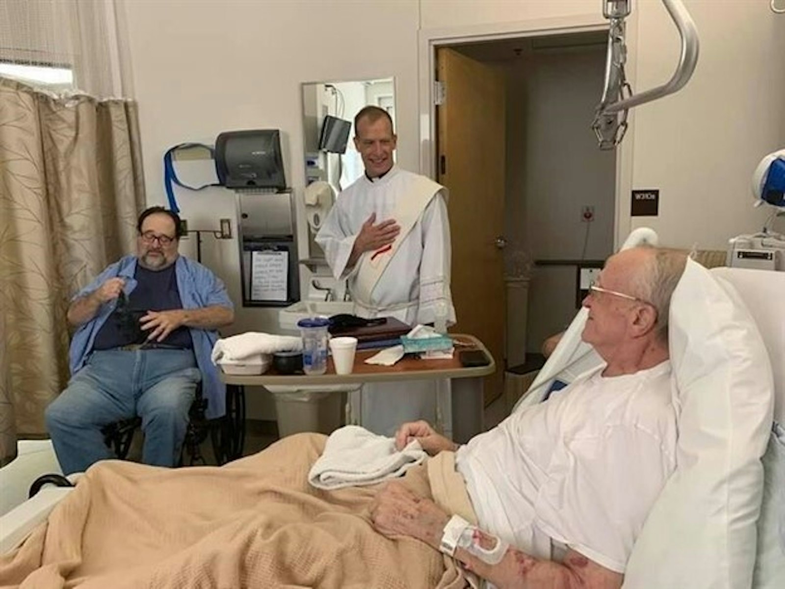 Dennis Ashby, left, after a deacon baptized one of two of his friends last August in his Iowa hospice. (Pictures courtesy of Carolyn Ashby)