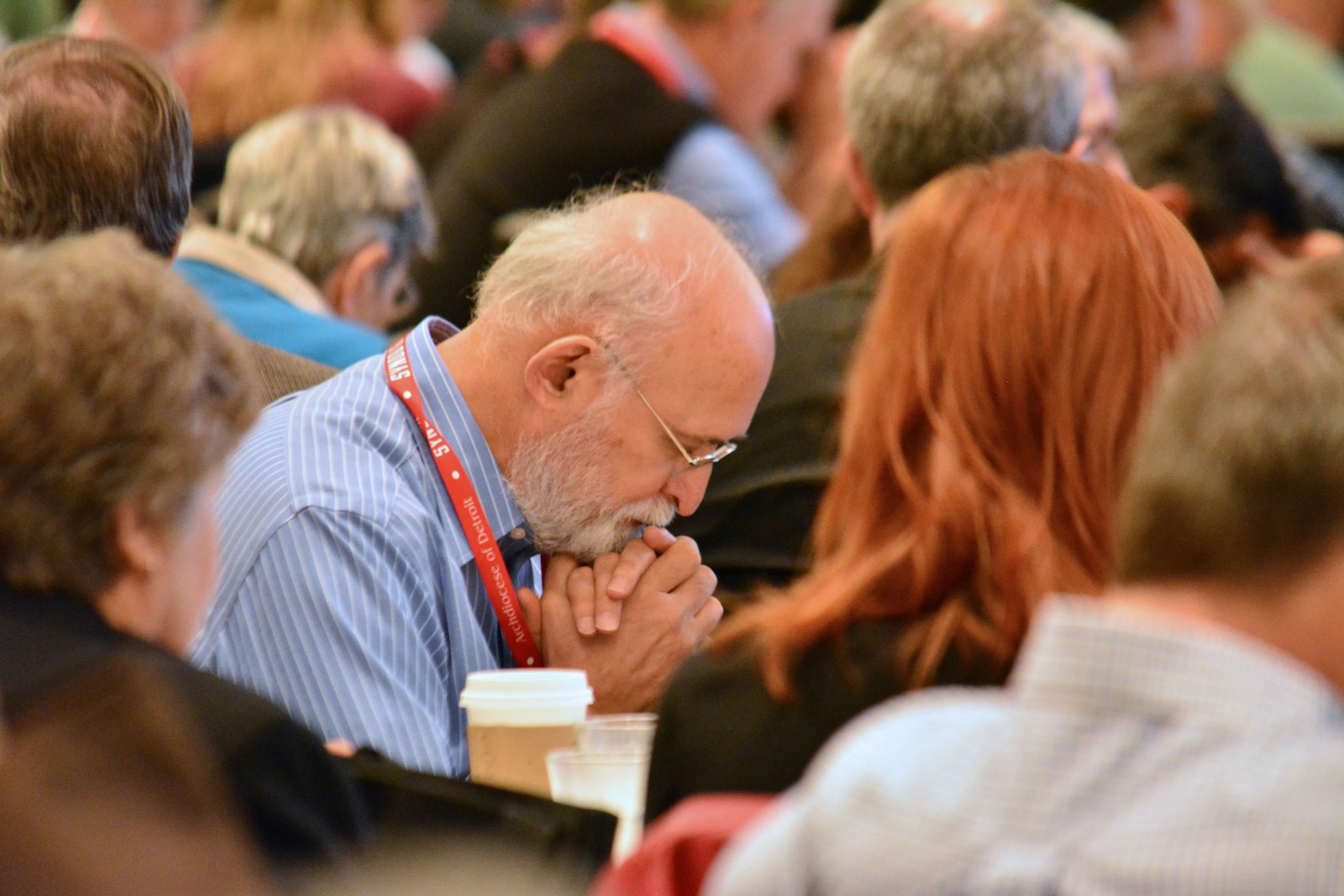 A synod member bows his head in prayer during one of the synod sessions. An emphasis on intercessory prayer, both at the parish and archdiocesan level, is one of the many lasting fruits of Synod 16, members say. (Michael Stechschulte | Detroit Catholic)