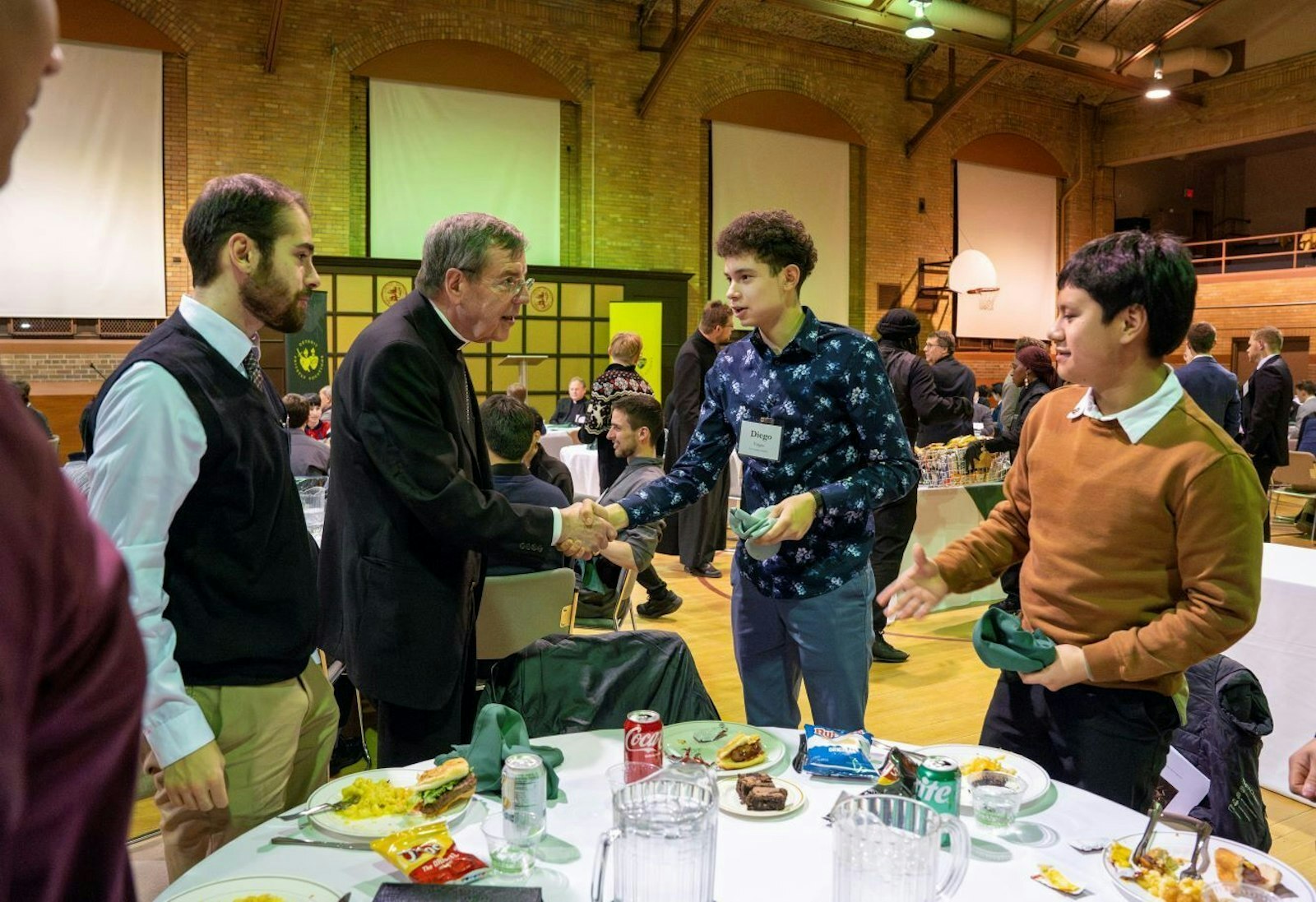 El Arzobispo Allen H. Vigneron saluda a jóvenes en el gimnasio del Sacred Heart Major Seminary el 18 de febrero de 2025, durante una noche anual de oración y cena organizada por la Oficina de Vocaciones Sacerdotales. (Valaurian Waller | Detroit Catholic)