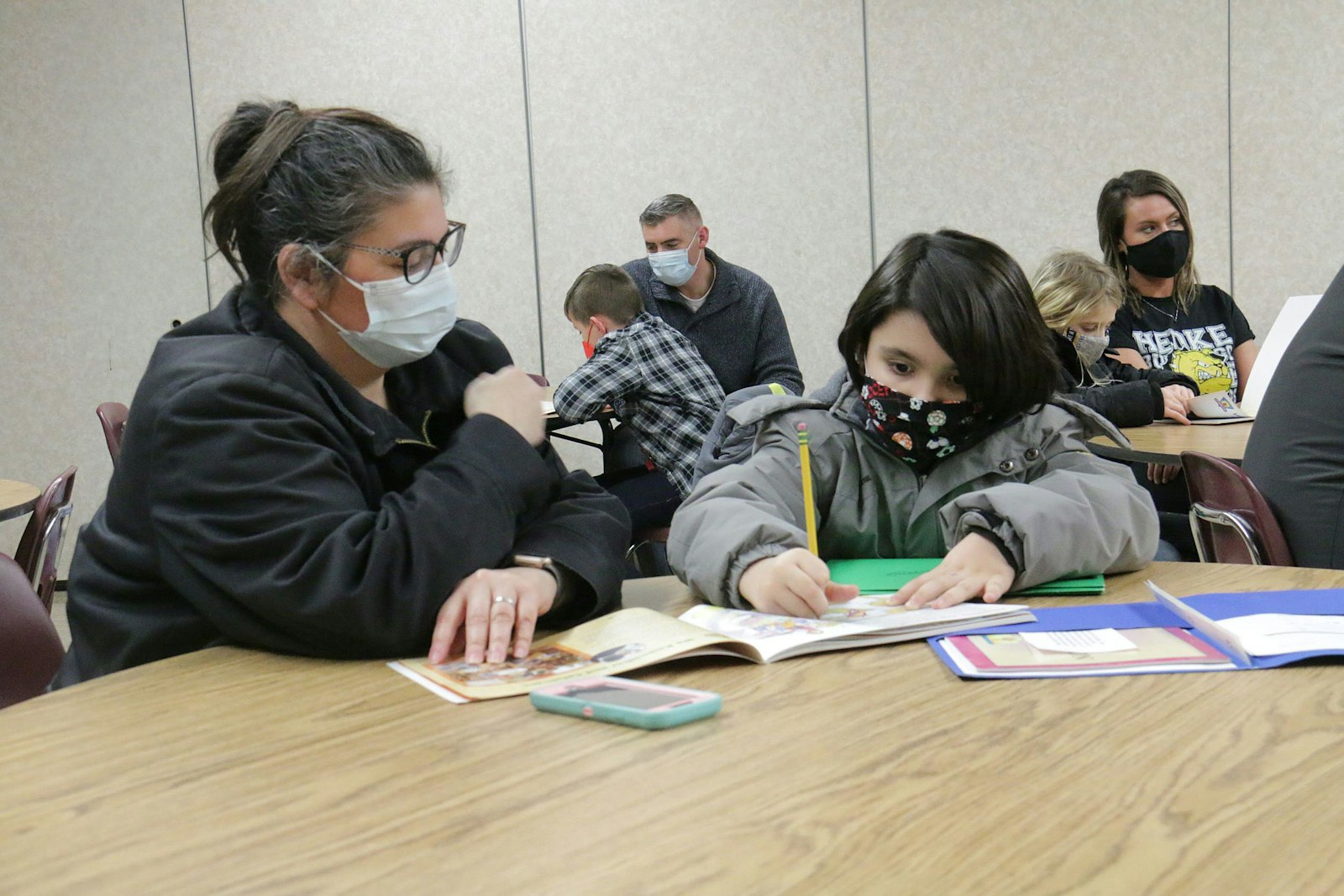 A parent and child sign a promise to pray together during a sacramental prep class at St. Cyprian Parish in Riverview. Under the Family of Parishes model, the director of discipleship formation oversees sacramental preparation.