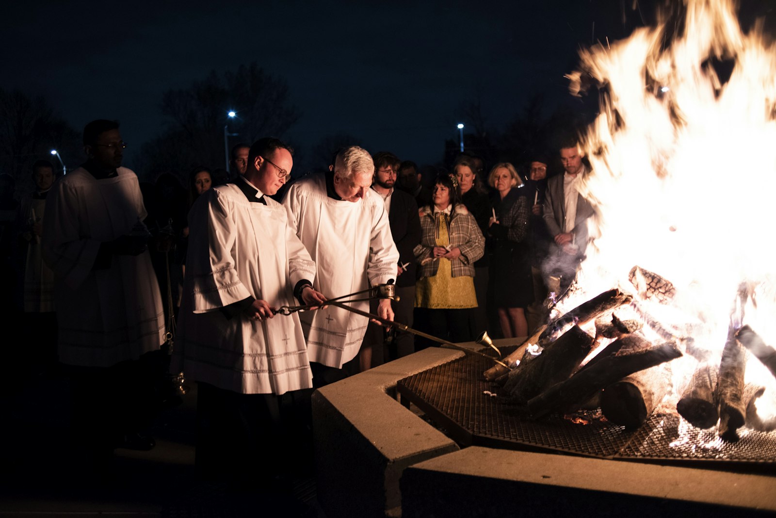 Seminarians Richard Dorsch Jr., left, and Patrick Bruen tend to the Easter fire in the plaza of the Cathedral of the Most Blessed Sacrament before Mass begins.