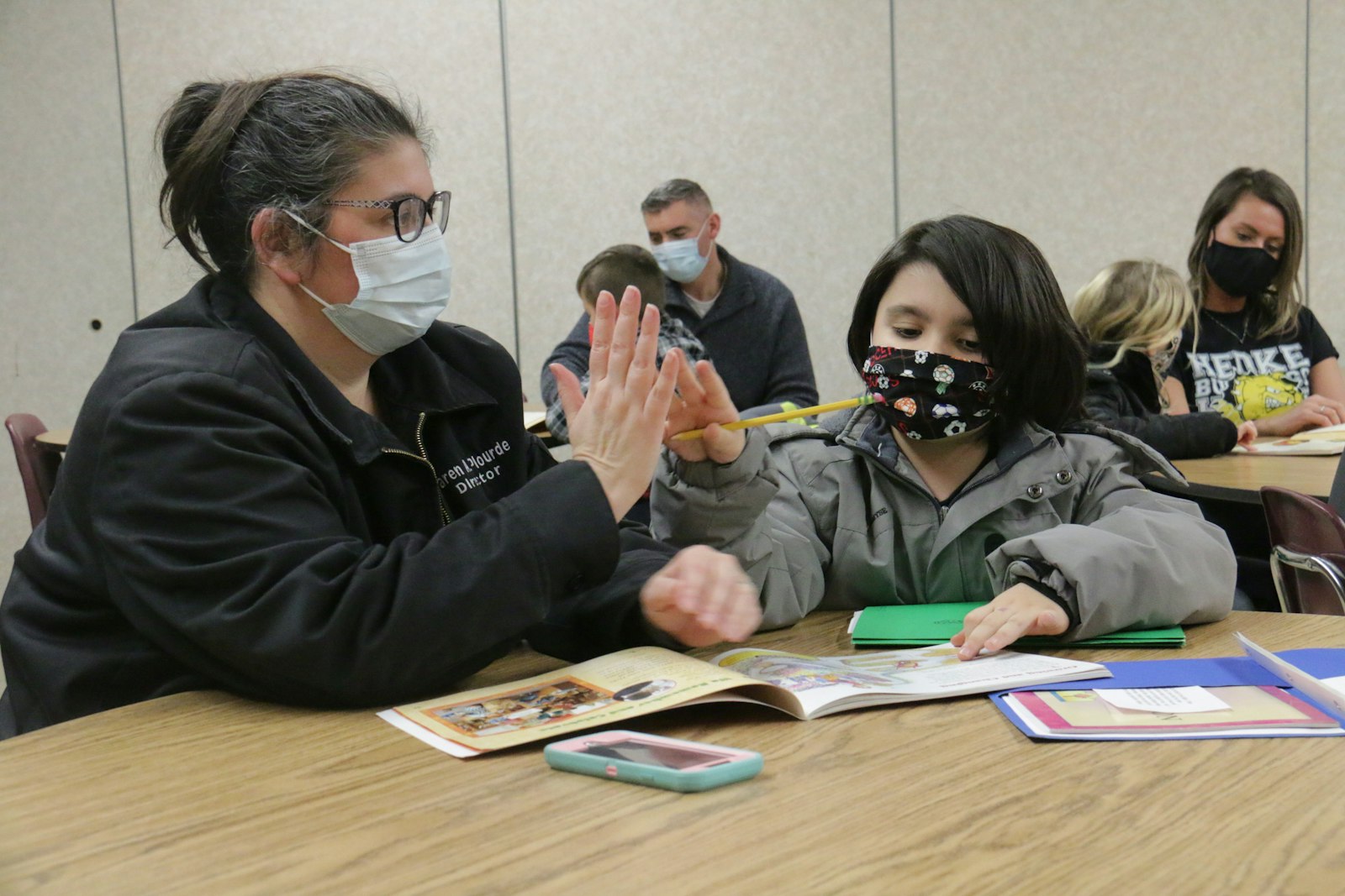 A parent and child sign a promise to pray together during a sacramental prep class at St. Cyprian Parish in Riverview. Under the Family of Parishes model, the director of discipleship formation oversees sacramental preparation for each parish in the family, allowing for greater collaboration and cooperation among parishes in the family. (Dan Meloy | Detroit Catholic)