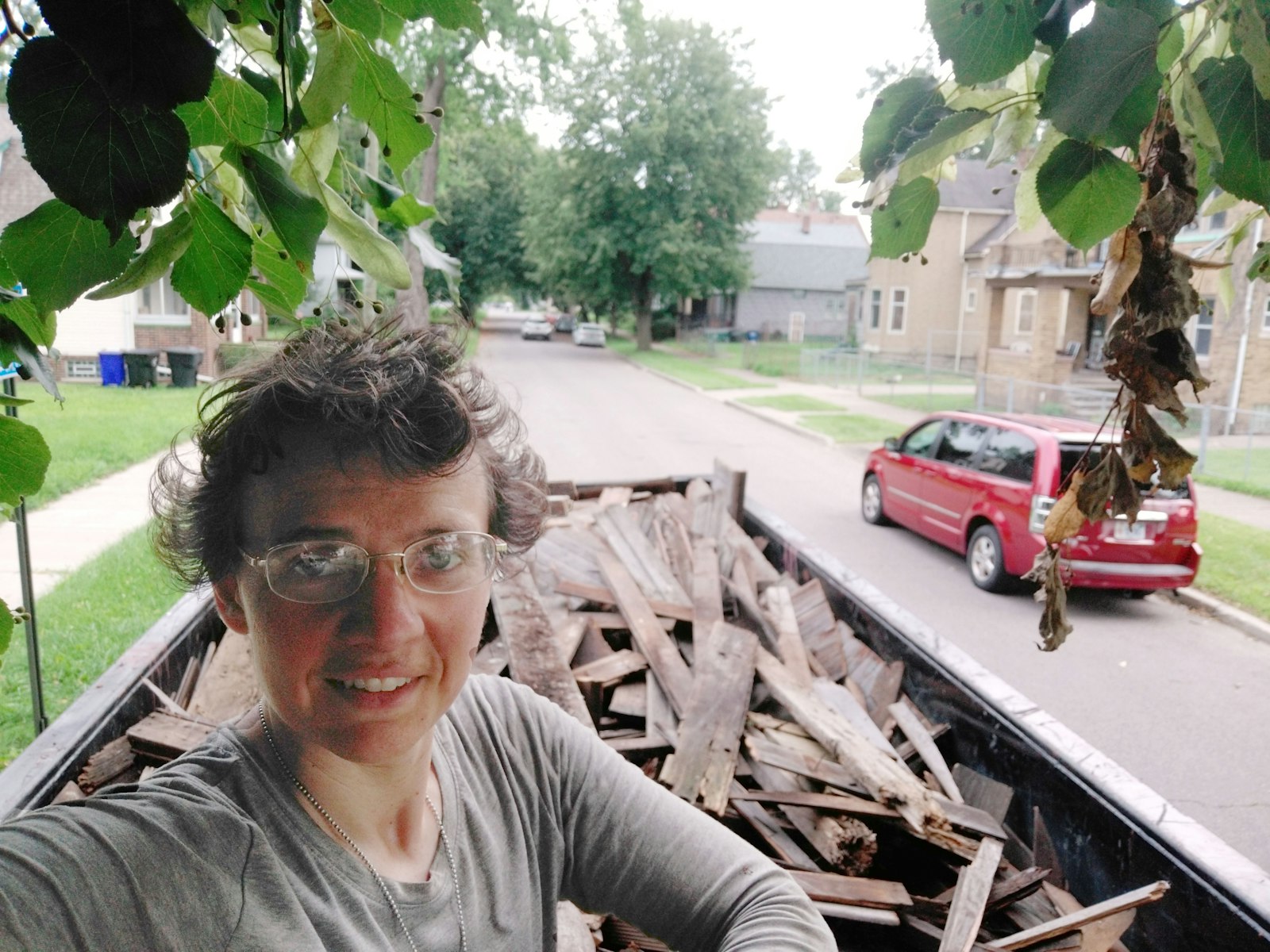 Genevieve Kocourek stands in front of a trailer after her organization, Firm Foundations of Hope, helped tear down a garage for an east-side resident. (Courtesy of Genevieve Kocourek)