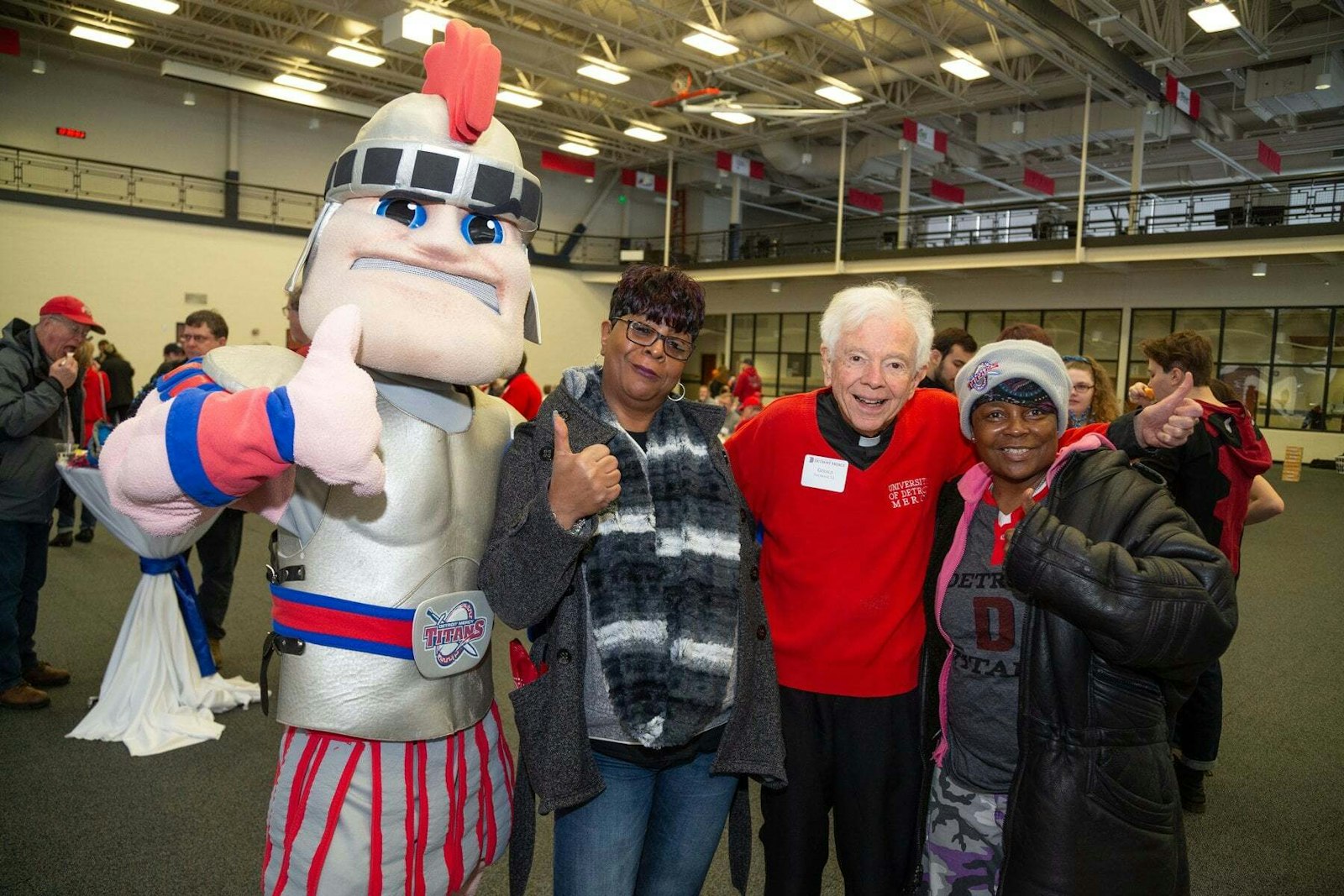 In addition to his rigorous academic pursuits, Fr. Cavanagh enjoys spending time with students, faculty and staff on campus. He is often found at Titans basketball games wearing his trademark red sweater. (Courtesy of the University of Detroit Mercy)