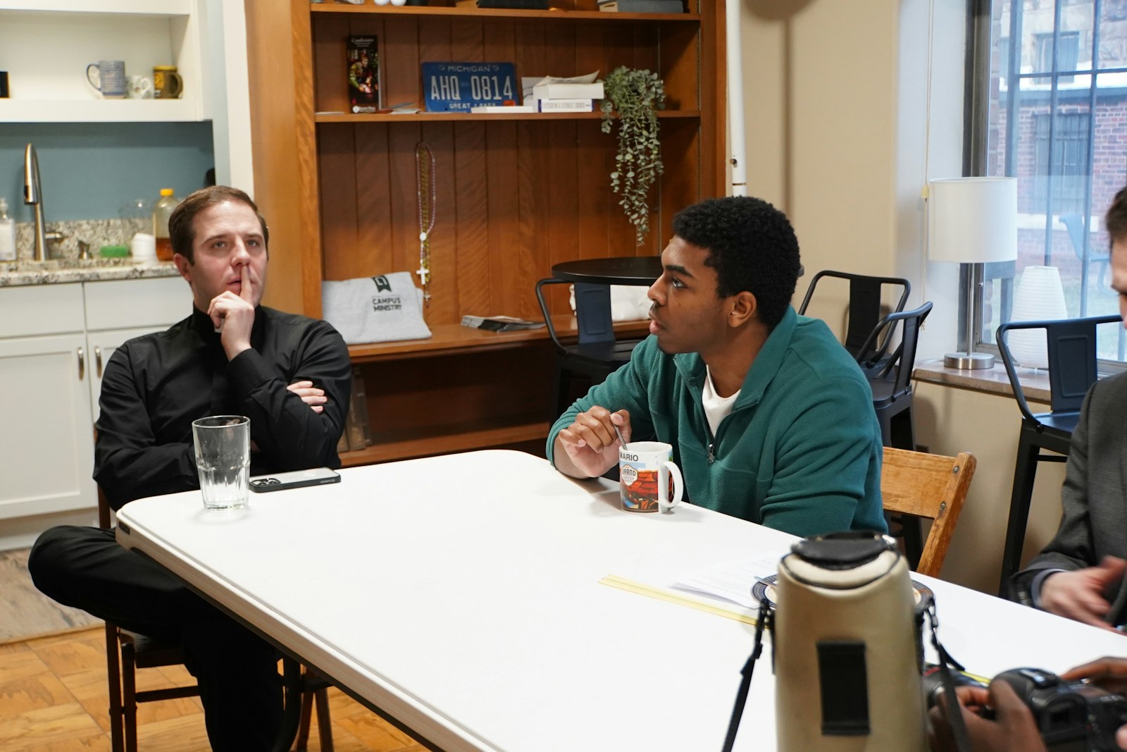 Fr. Matthew Hood, left, is the chaplain and director of Detroit Catholic Campus Ministry. He, along with campus ministry coordinators, organize Sunday Suppers following Mass.