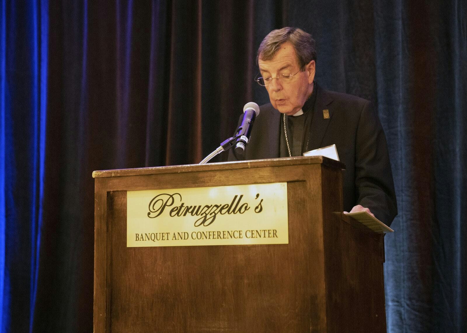 El Arzobispo Allen H. Vigneron bendice los alimentos antes de cenar. El arzobispo agradeció a los que apoyan a Catholic Charities of Southeast Michigan, la agencia principal para las obras de misericordia de la Arquidiócesis de Detroit.
