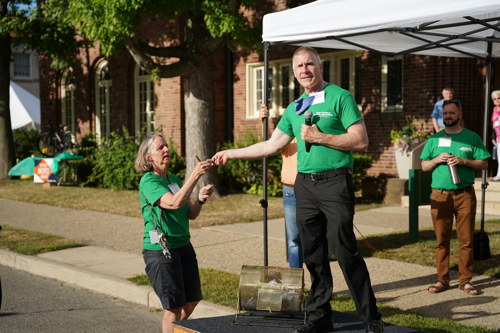 Fr. Lorn Snow, SJ, pastor of Gesu Parish, pulls a ticket for the parish raffle. The centennial celebration featured food trucks, a DJ and tours of the church and school.