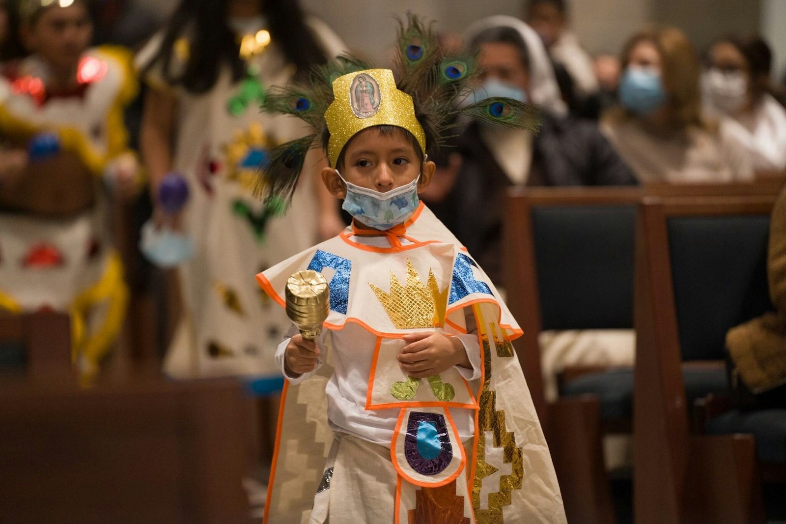 A child dresses in traditional Aztec garb during a pre-Mass performance. The feast of Our Lady of Guadalupe celebrates the Blessed Virgin Mary's appearance to St. Juan Diego in 1531, which resulted in the conversion of Mexico.