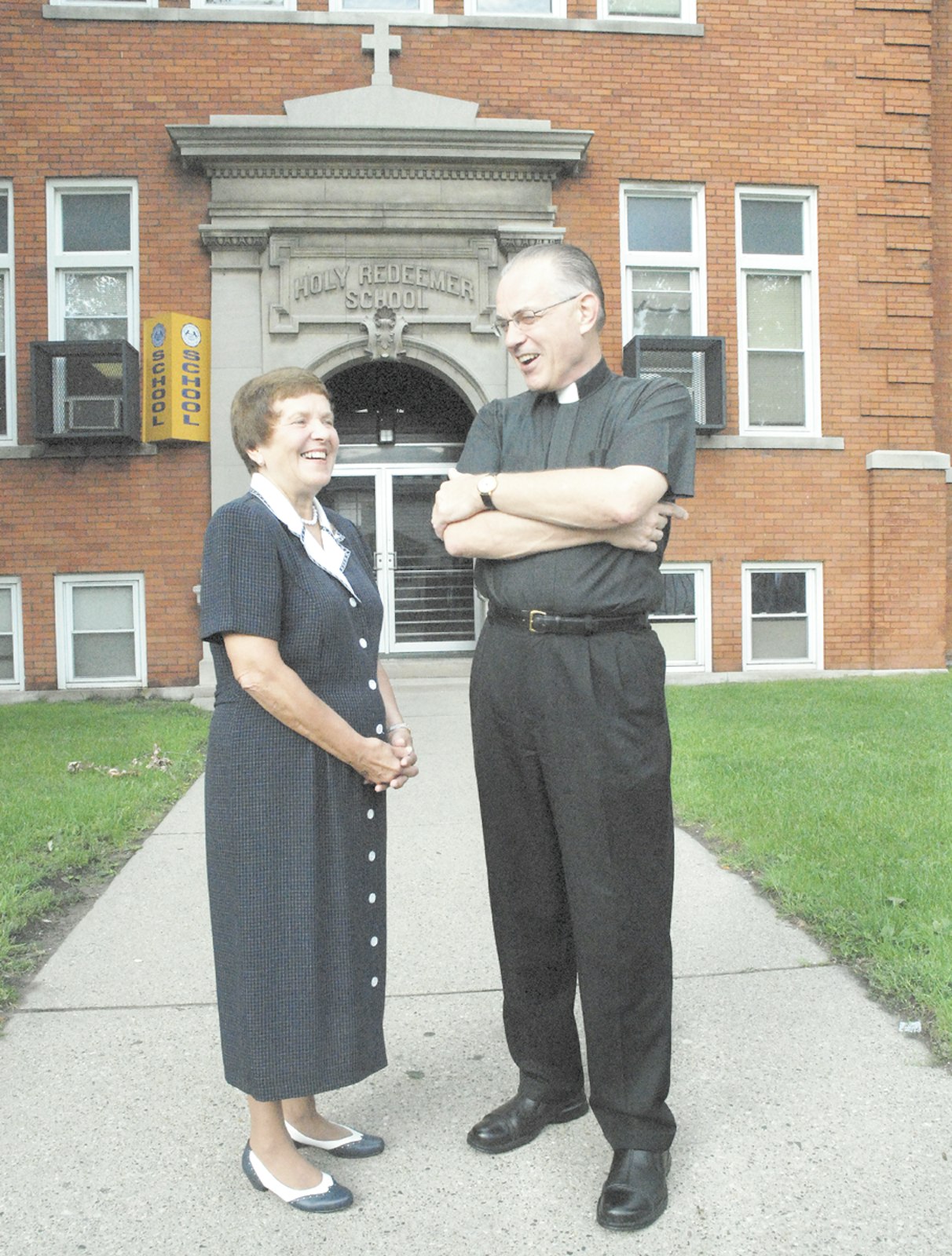 Sr. Elizabeth Fleckenstein, principal of Holy Redeemer Grade School, and then-Msgr. Donald Hanchon, pastor of Most Holy Redeemer Parish, talk about the history of the school in August 2007. (Robert Delaney | The Michigan Catholic)