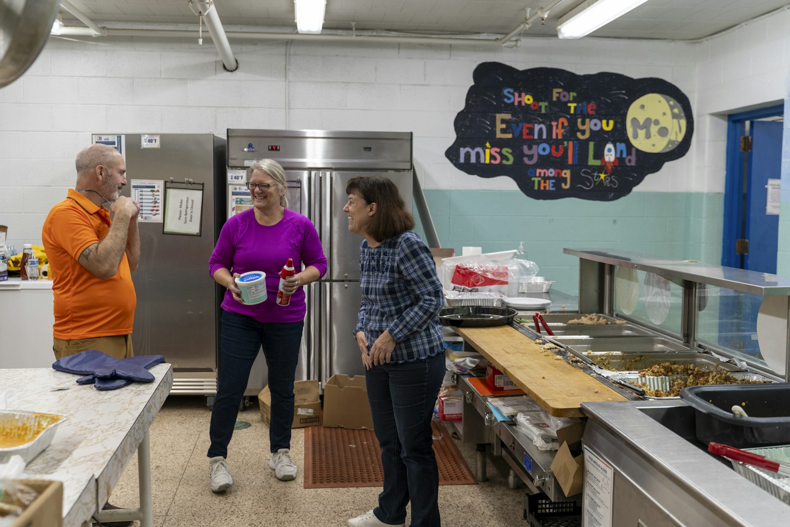 Volunteers laugh in the kitchen while cleaning up a Thanksgiving meal Nov. 23 at Most Holy Trinity, a staple for the community's homeless men and women who enjoy a home-cooked meal and fellowship. (Valaurian Waller | Detroit Catholic)