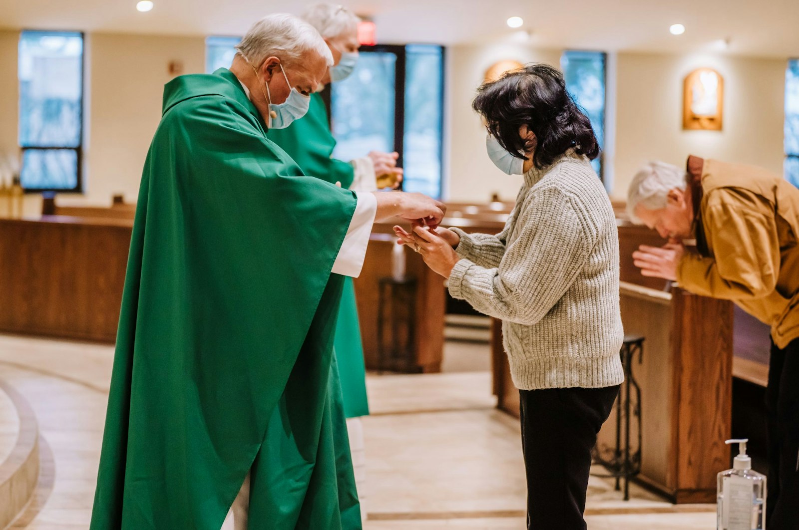 La voluntaria May Faraon recibe la Eucaristía en la Iglesia Holy Family de Novi el 14 de enero. La voluntaria lleva la comunión a los confinados de la parroquia todos los viernes, un ministerio al que se ofreció después de ver lo mucho que significaba para su propia madre recibir la Eucaristía después de quedarse confinada en casa.