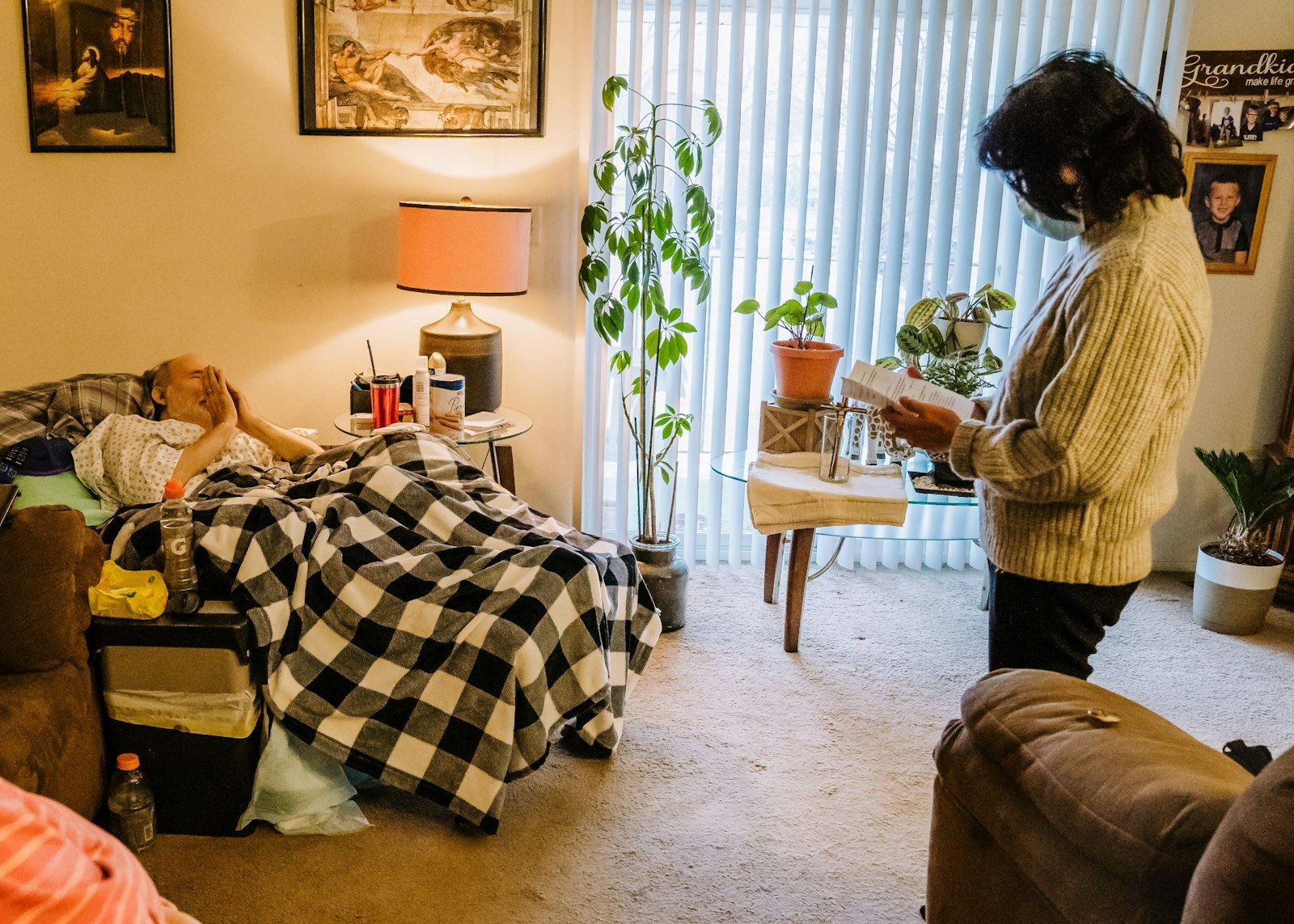 May Faraon prays with Keith Gouba in Gouba's home on Jan. 14 before offering him Communion.