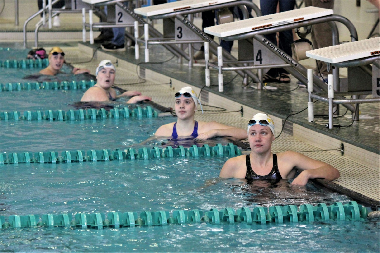 Bishop Foley’s Danielle Tews, and Mercy’s Lily Cochrane, Sydney Derkevorkian and Madeline Basa check their times after completing the 100-yard backstroke. They were the top four swimmers in the event, with Derkevorkian winning in 58.91 seconds.