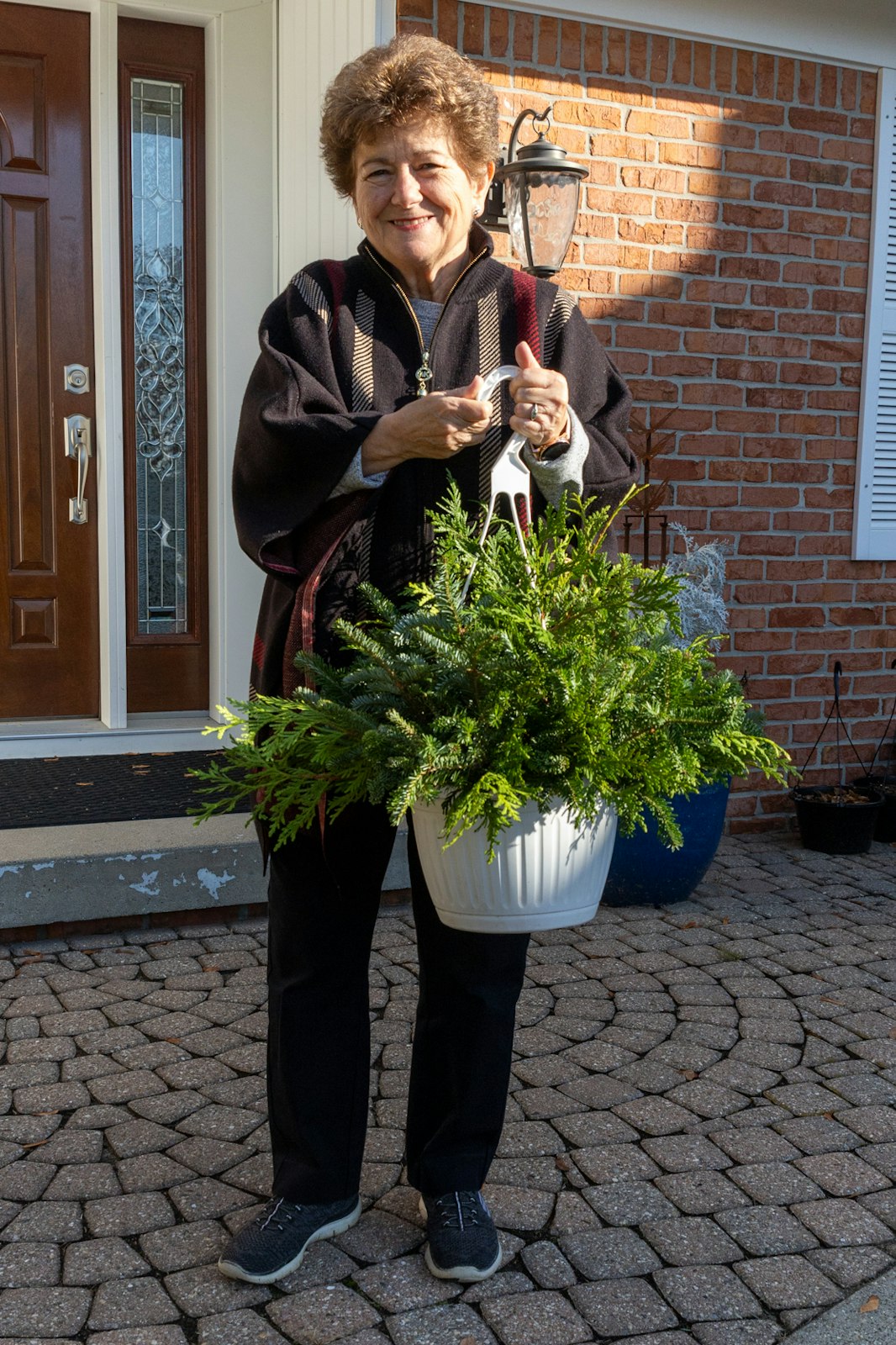Catherine Genovese holds one of the hanging baskets for sale at Candy Cane Christmas Tree Farm.