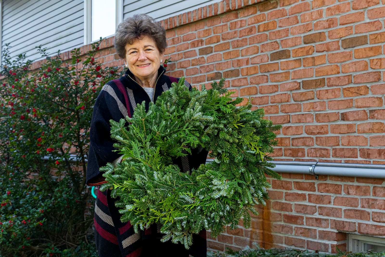 Catherine Genovese holds a wreath made for sale at Candy Cane Christmas Tree Farm. The farm opens for the season the weekend before Thanksgiving each year.