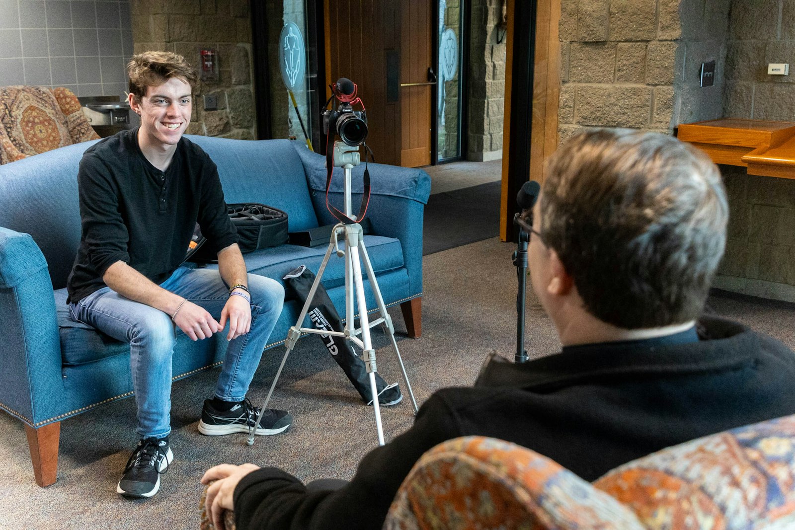 Jacob Sasak interviews Fr. Jim Kean as part of his four-part docuseries, "The Life of a Priest," at St. Joseph the Worker Parish in Lake Orion. Sasak hopes to use his talents as a videographer to "give glory to God" and to inspire others to do the same.