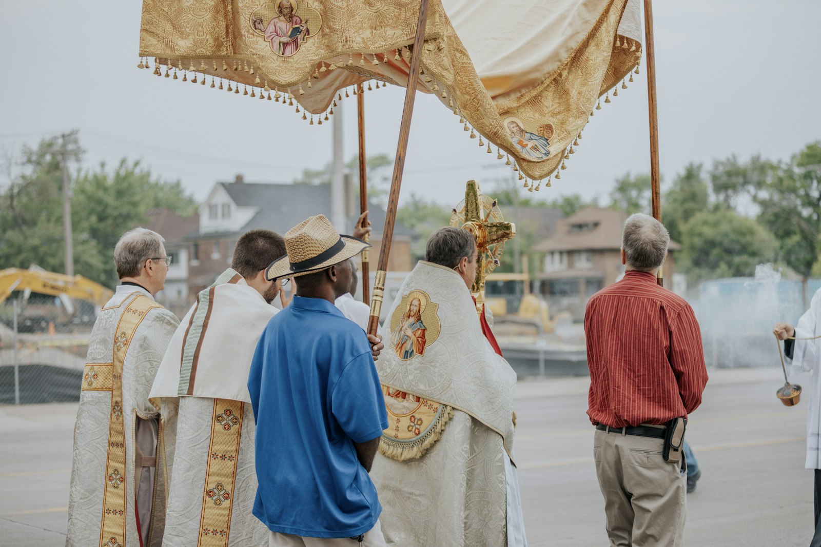 Archbishop Vigneron holds the monstrance containing the Eucharistic Jesus as the procession passes by the construction site of the Cathedral Arts Apartments, a new venture that will build 53 affordable housing units for Detroit's low-income residents across the street from the Cathedral of the Most Blessed Sacrament. (Alissa Tuttle | Special to Detroit Catholic)