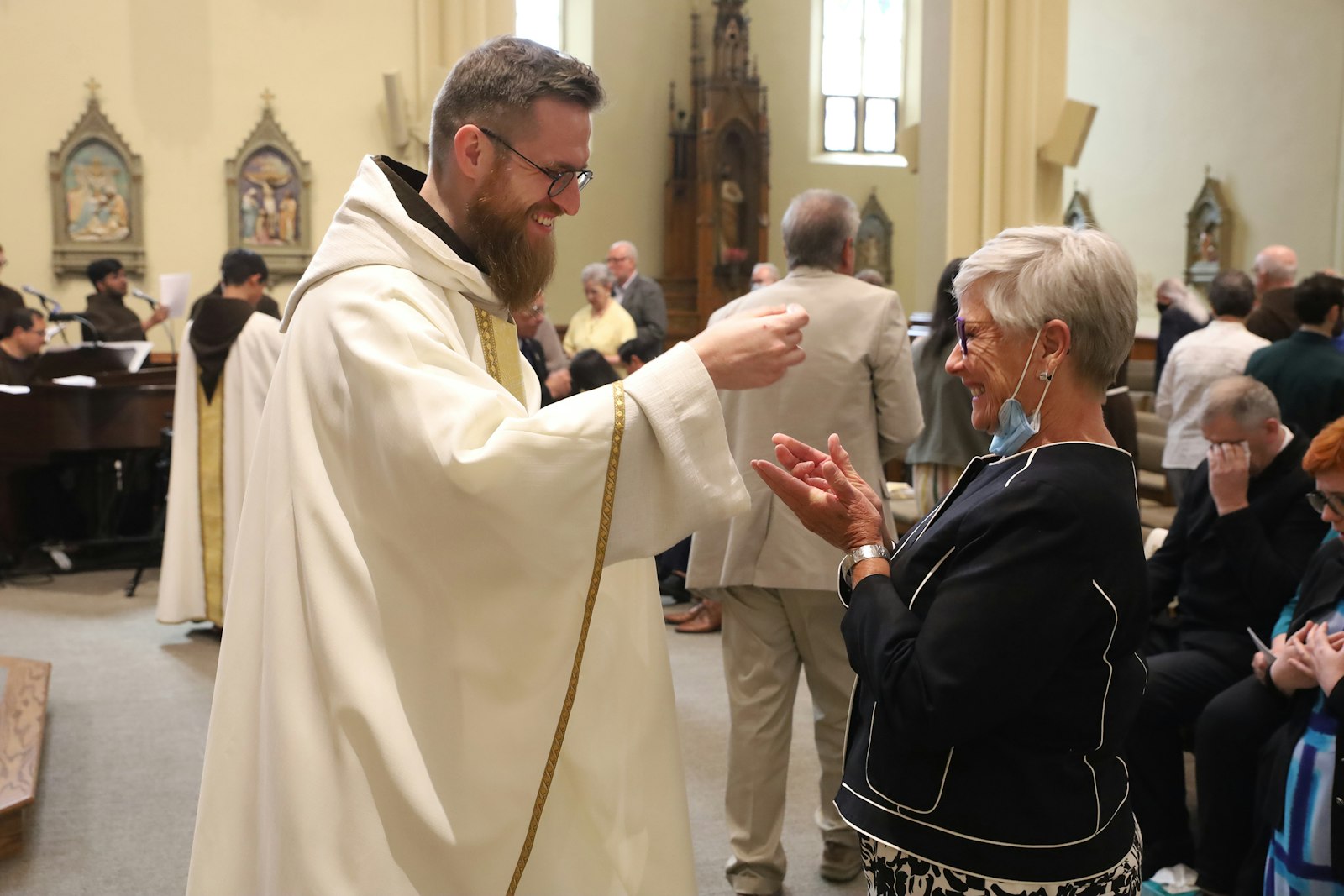 Fr. Skowron smiles broadly as he offers Communion to friends, family and well-wishers during his ordination Mass on June 4 at St. Bonaventure Monastery in Detroit.