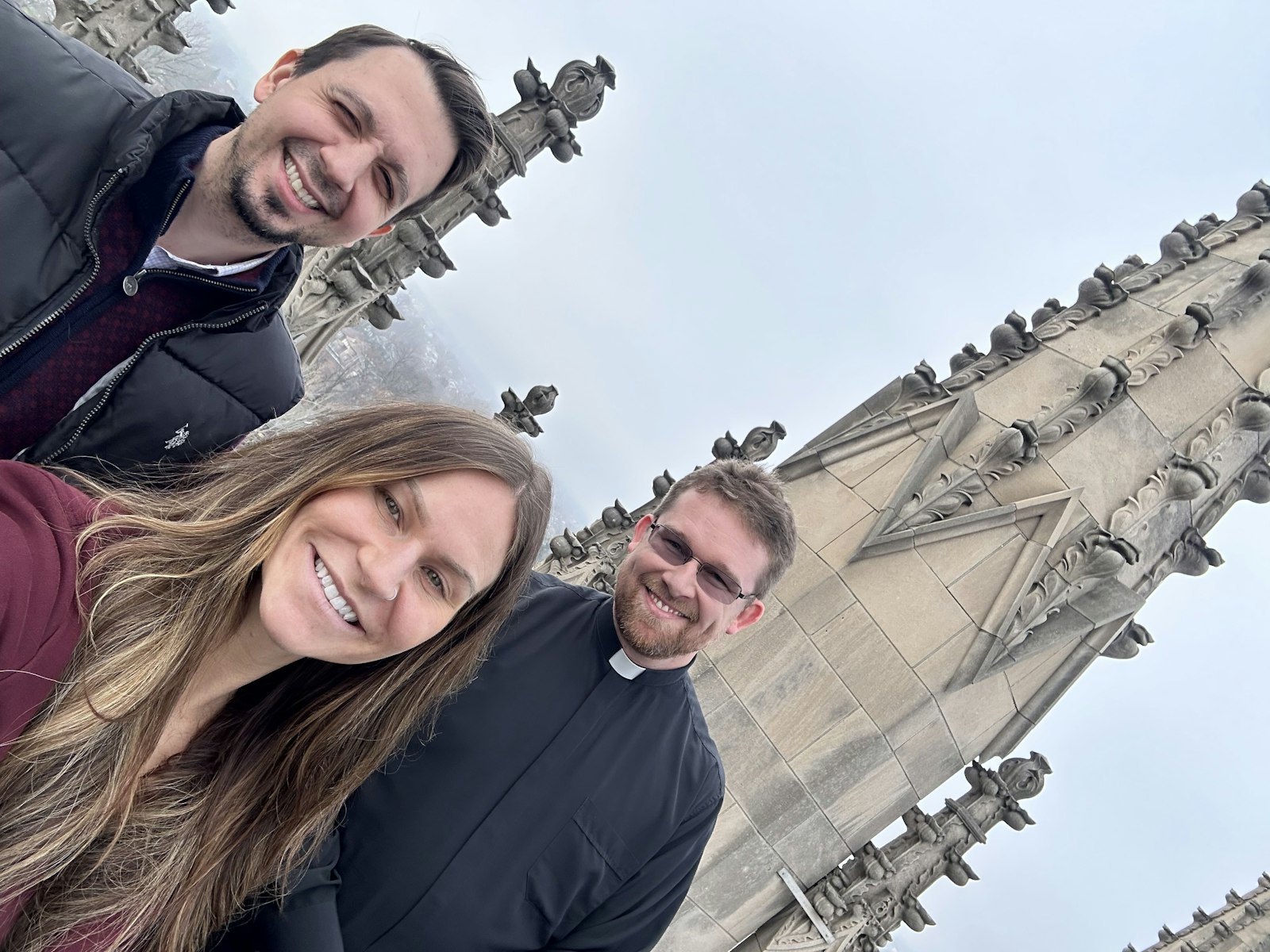 Kevin and Melissa Blanchard take a selfie with Father Dave Tomaszycki on the roof of the Cathedral of the Most Blessed Sacrament in Detroit after attending Mass at the cathedral on Christmas Day 2023. (Amber Marie Photography | Special to Detroit Catholic)