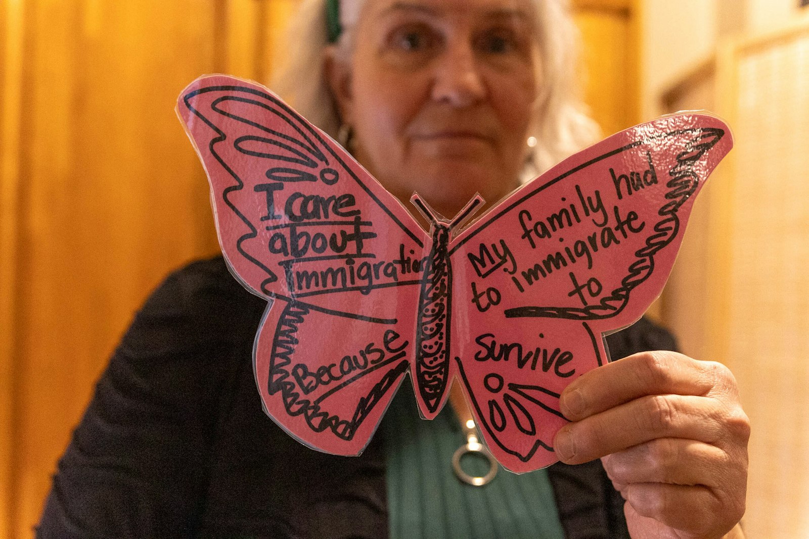 Cristo Rey campus minister Kim Redigan holds a butterfly created by a student expressing a reflection on the student's family's immigration journey. Because Cristo Rey's community includes immigrants of a diverse background, the mural was intended to include representations of many cultures and backgrounds.