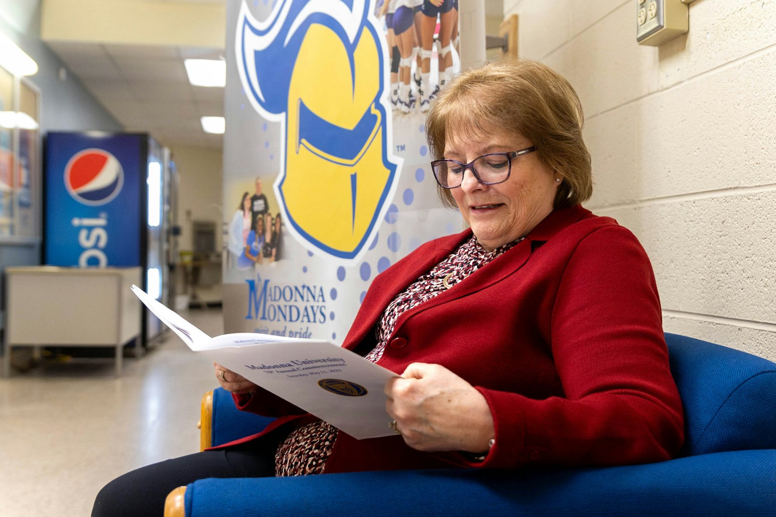 Marianne Burnett reads a program for Madonna's lay chaplaincy program, which trains people to serve as spiritual caregivers in a variety of pastoral settings and to those of all faiths.