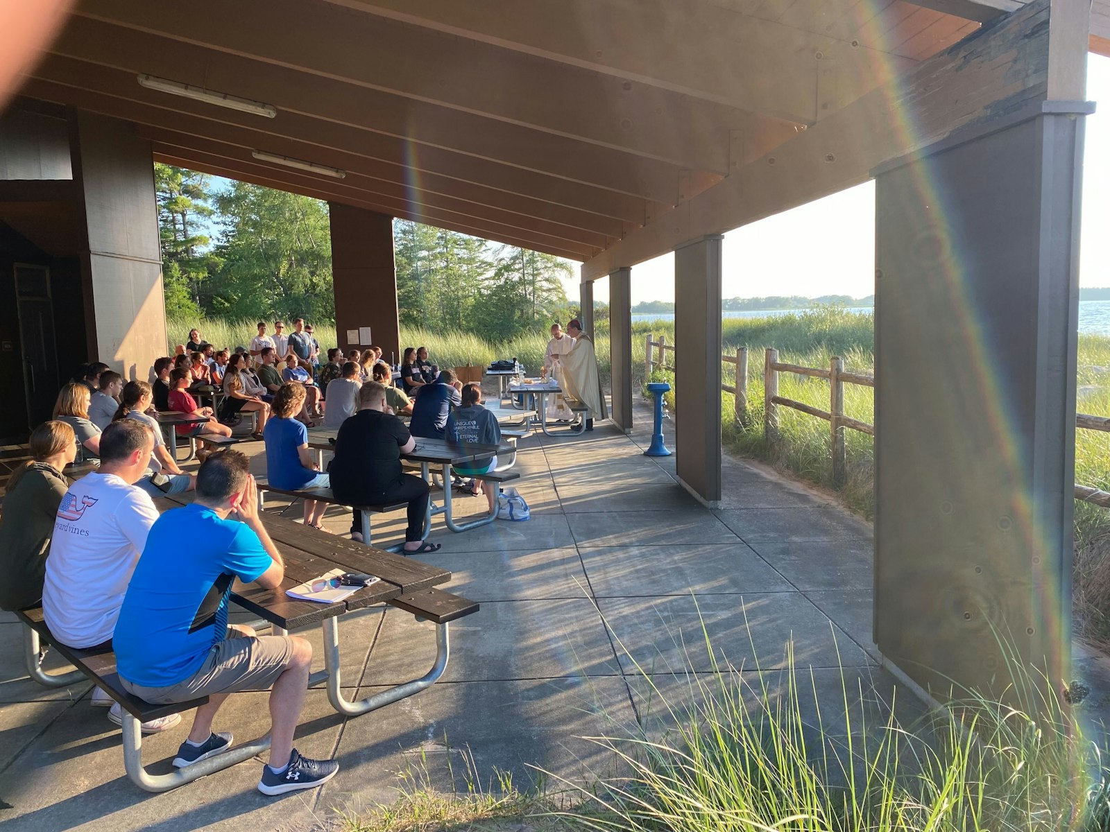 Bishop Jeffrey Walsh of Gaylord celebrates Mass in a pavilion on the shores of Lake Huron on Friday night during the Michigan Young Adult Hiking and Rafting Pilgrimage. Bishop Walsh thanked the 70 retreatants for bearing witness to Christ in his diocese.