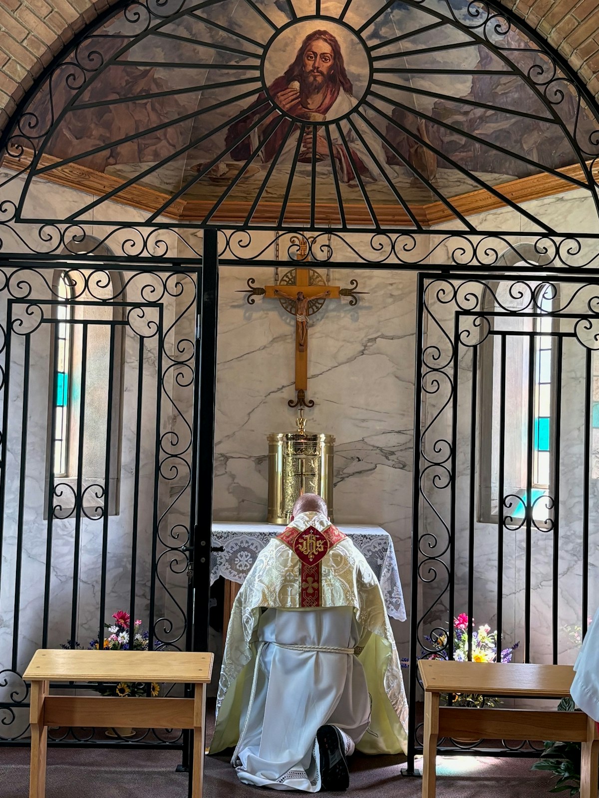 Fr. John Kopson kneels before the tabernacle during the opening Mass for the parish's new perpetual adoration chapel.