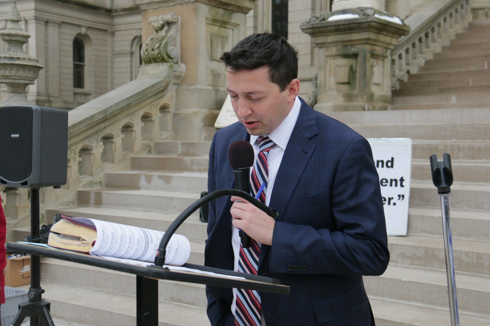 Michigan State. Rep Steve Carra reads from Scripture before the steps of the Michigan Capitol during a prayer rally Nov. 30 in support of a pro-life decision in the Mississippi v. Jackson Women’s Health Center case before the U.S. Supreme Court. Carra explained the gathered assembly the case will specifically look at a state’s right to determine when a child in the womb is viable, a prospect that has been enhanced with technological enhancements.