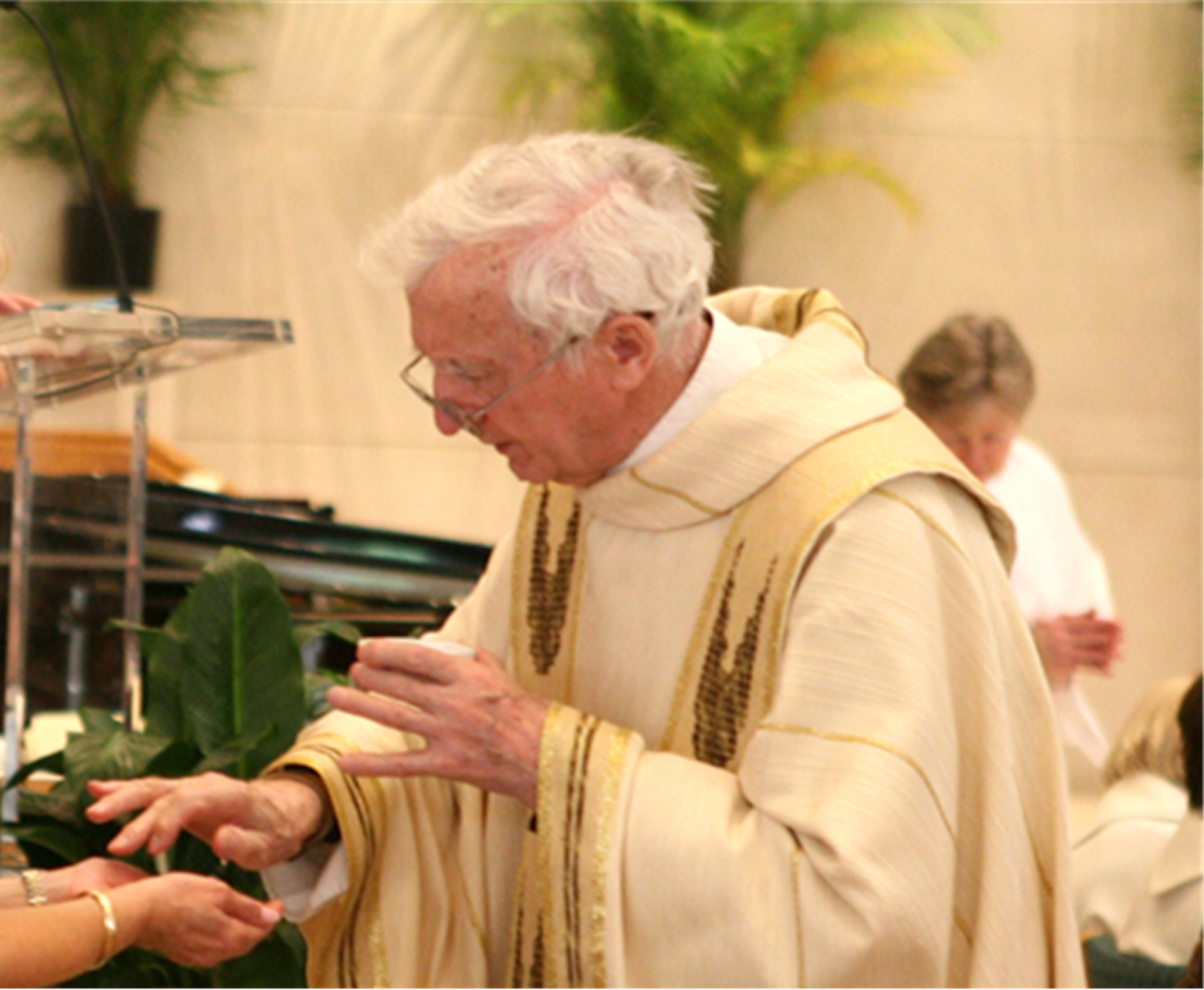 Fr. Szewczyk offers Communion during a Mass at St. Hugo of the Hills Parish in Bloomfield Hills, where he served the early Mass for decades. (Courtesy of St. Hugo of the Hills Parish)