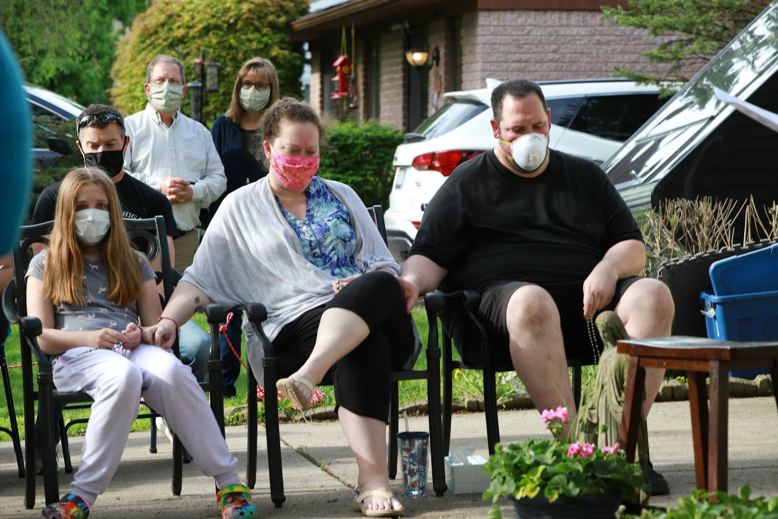 The Cavanaugh family prays while Fr. Livingston blesses friends and family gathered outside the home to pray with and for Amanda Cavanaugh in 2020.