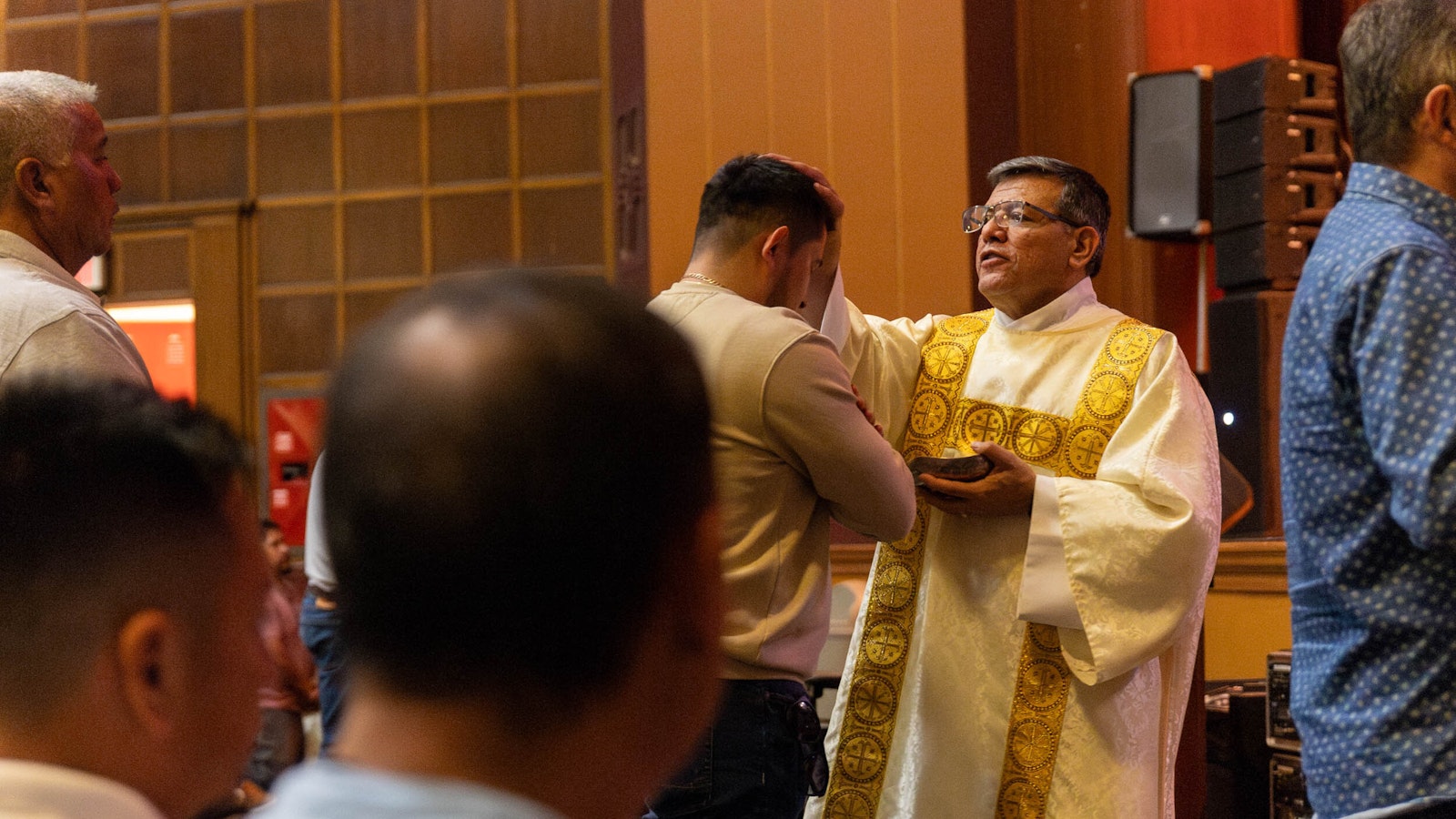 A man receives a blessing during Mass at the conference.