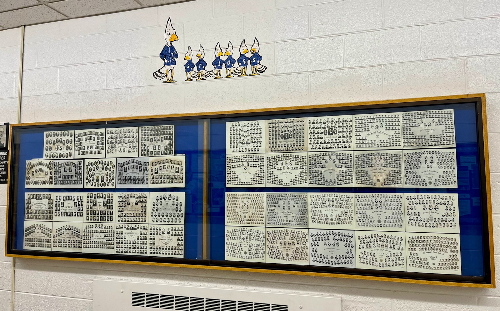 Class photos on the wall of De La Salle Collegiate in Warren pay tribute to the classes of St. Joseph High School.