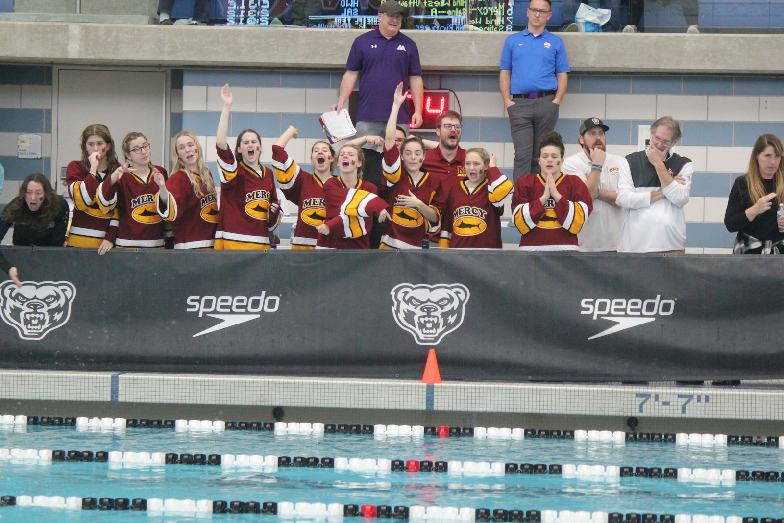 The Farmington Hills Mercy state qualifiers cheer on their teammates during the 400-yard freestyle relay at the Division 1 championship meet. (Wright Wilson | Special to Detroit Catholic)