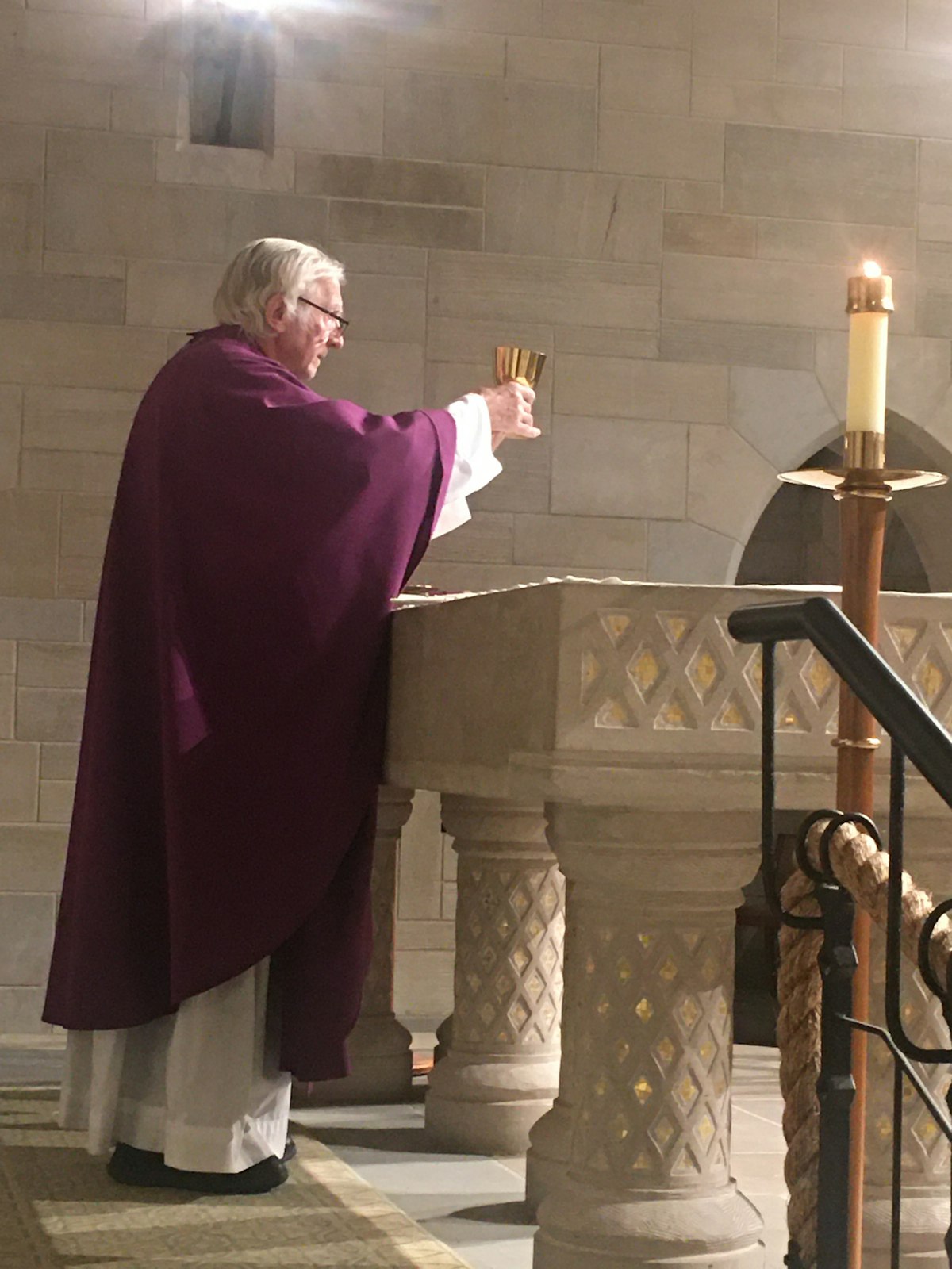 Fr. Szewczyk elevates the Eucharist while celebrating Mass in the Stone Chapel of St. Hugo of the Hills Parish in Bloomfield Hills.