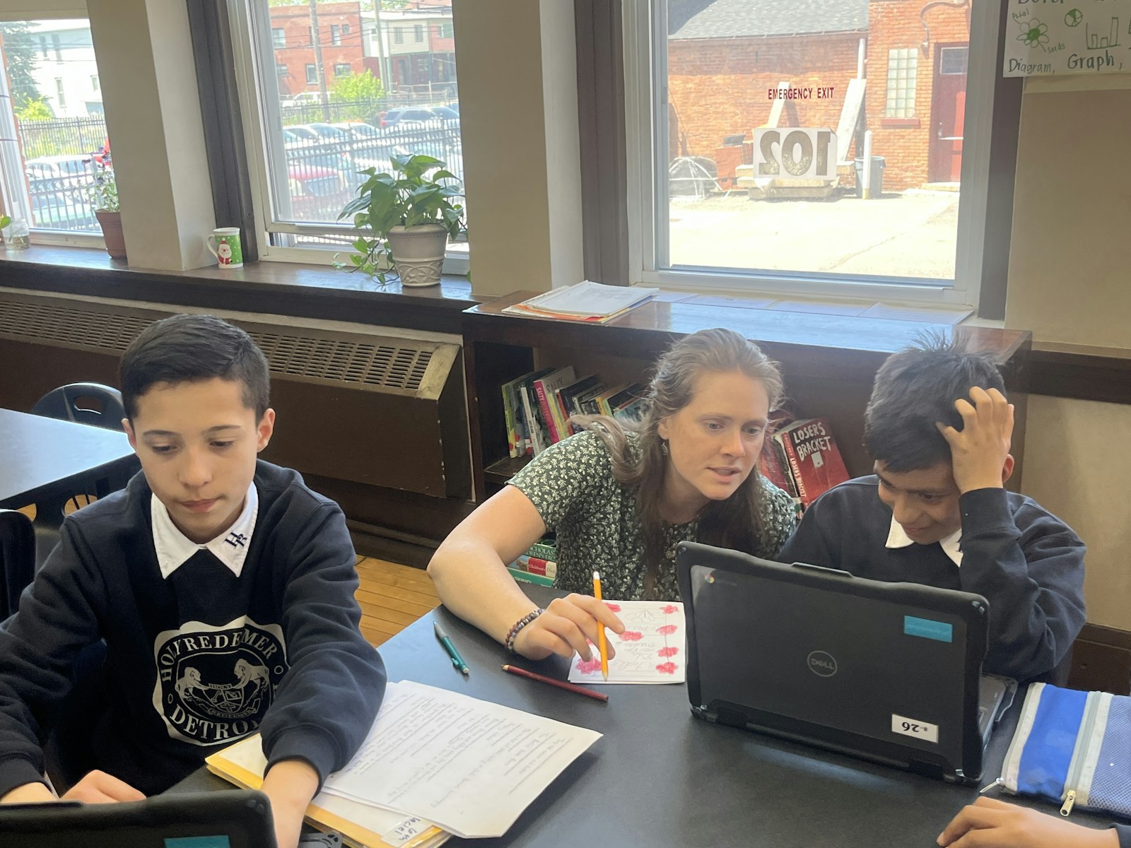 Claire McElroy works with a student in her sixth-grade class. McElroy obtained an education degree from the University of Alaska-Fairbanks before coming to Michigan and serving as one of the first SOLT missionaries to serve in Detroit. She plans to enter the SOLT aspirancy program.