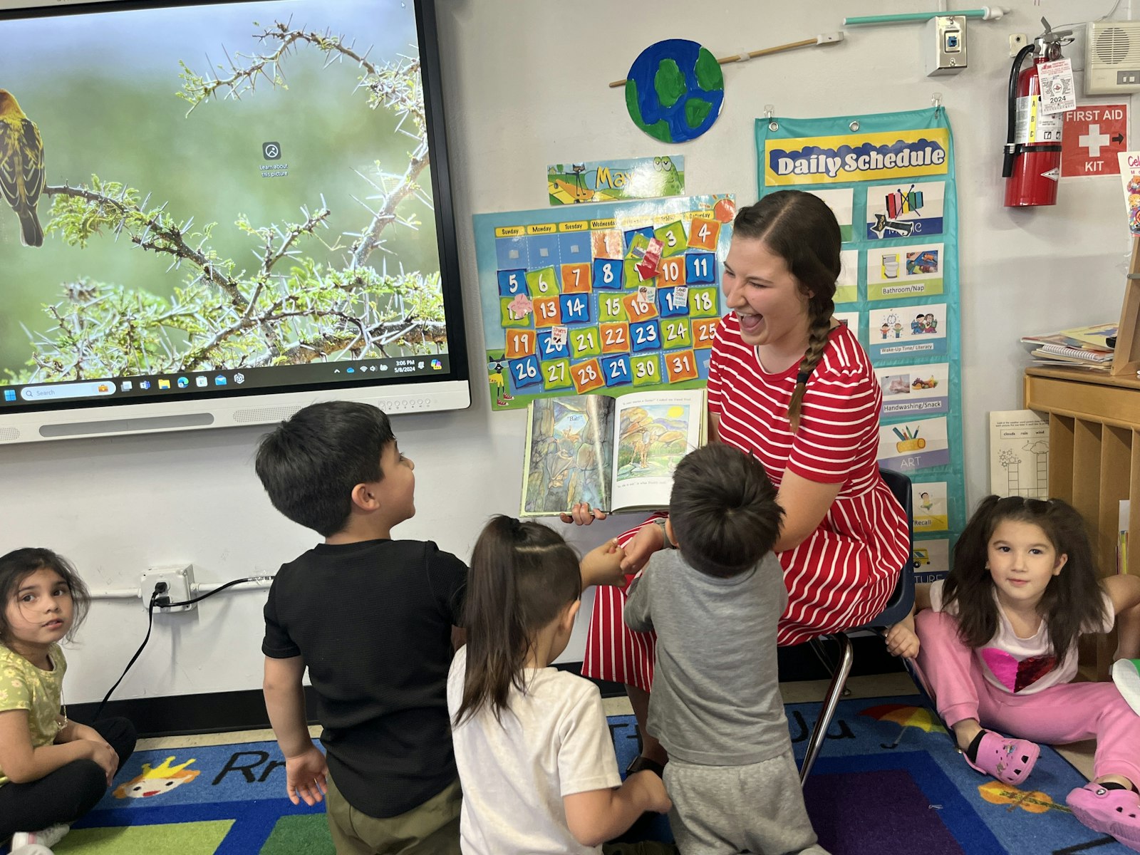 Brianna Moreland reads a book to preschoolers at Holy Redeemer School. Moreland is a preschool aide and assists with the school's Healthcare Career Club for middle schoolers.