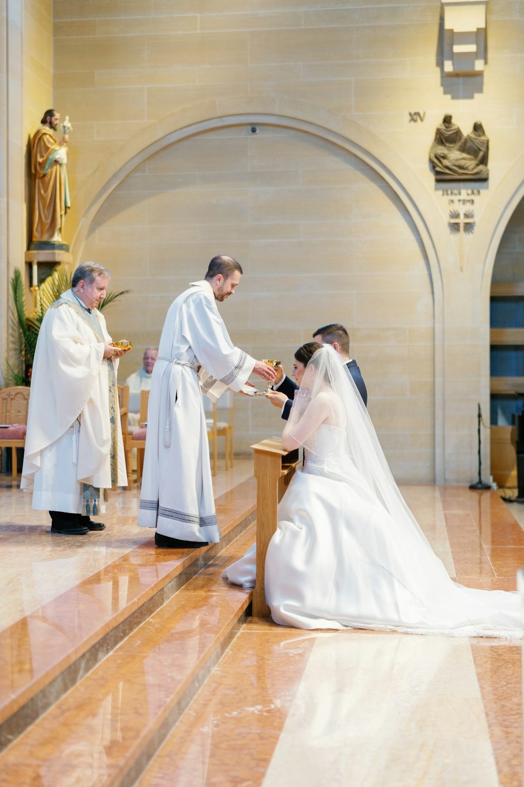 Fr. Paul Snyder offers Communion to Margaret and Ben Diaz during their wedding on May 13, 2023, at St. Mary Parish in Royal Oak, as Bishop Robert J. McClory, left, Margaret's uncle, looks on. (Photos by Shannell Photography | Special to Detroit Catholic)