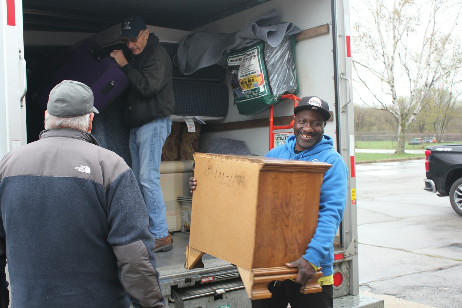 Voluntarios descargan muebles de un U-Haul el 17 de abril para entregarlos en la casa Pontiac de un cliente que llamó al Equipo de Respuesta de la Comunidad Católica en busca de ayuda.