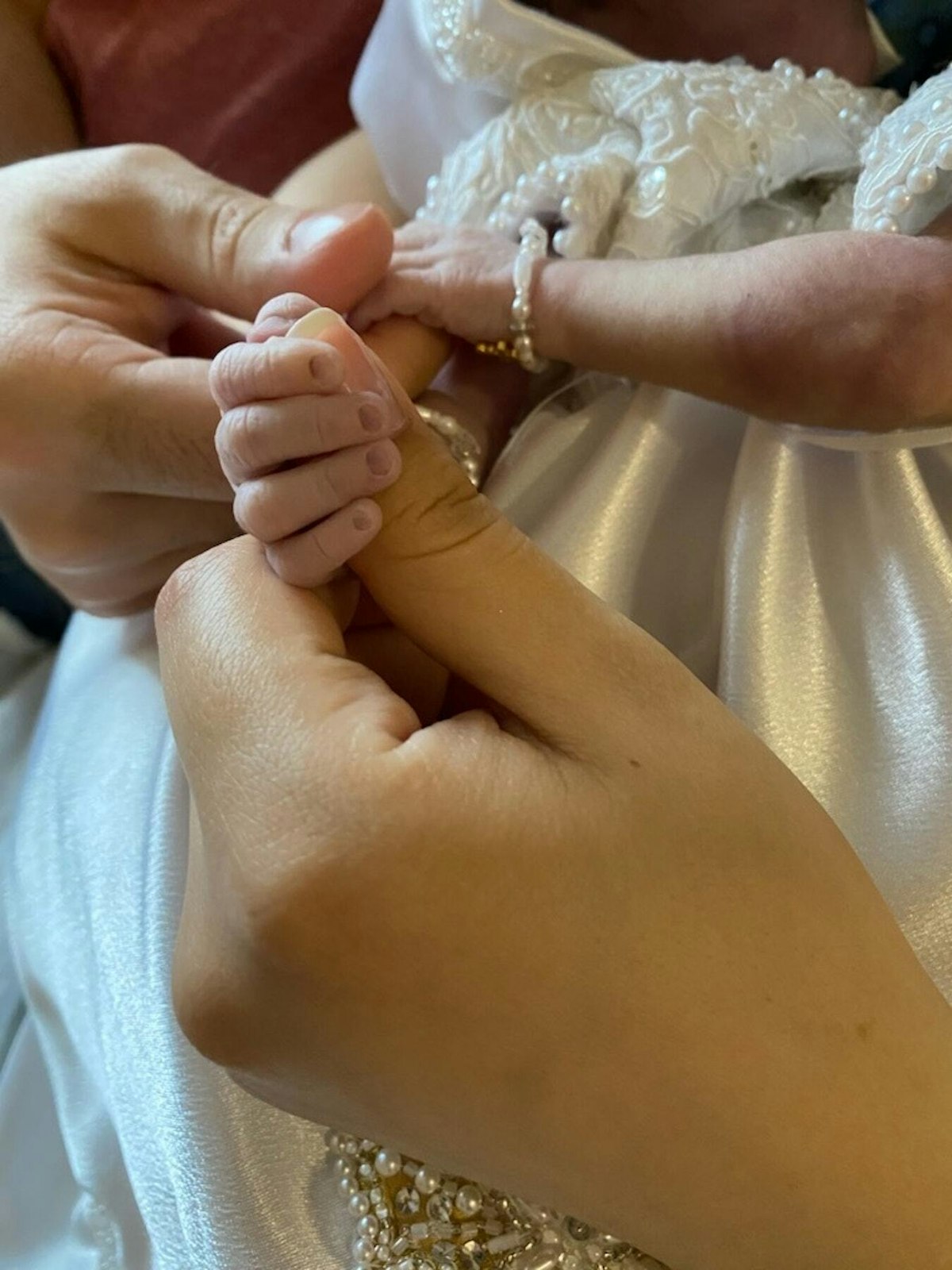 Nicole Duque tenderly holds the hand of her precious twins, Maria Theresa and Rachel Clare.