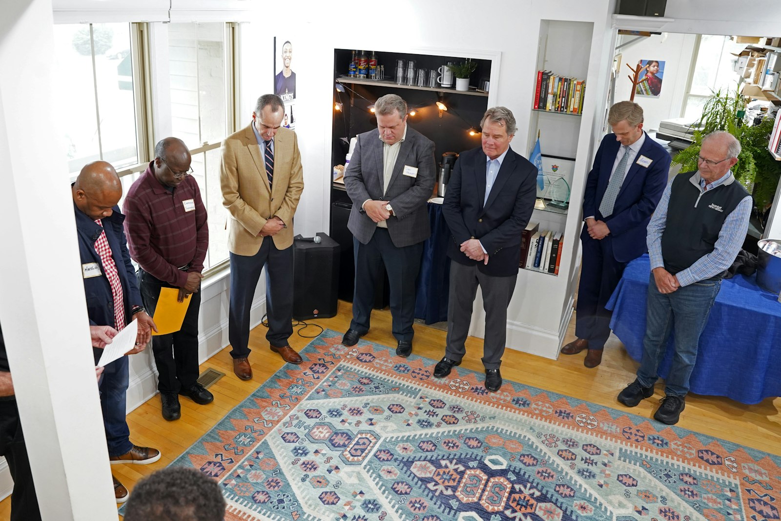 International Samaritan board members and supporters pray during a flag-raising ceremony April 28 outside the nonprofit's Ann Arbor headquarters to mark its expansion in east Africa.