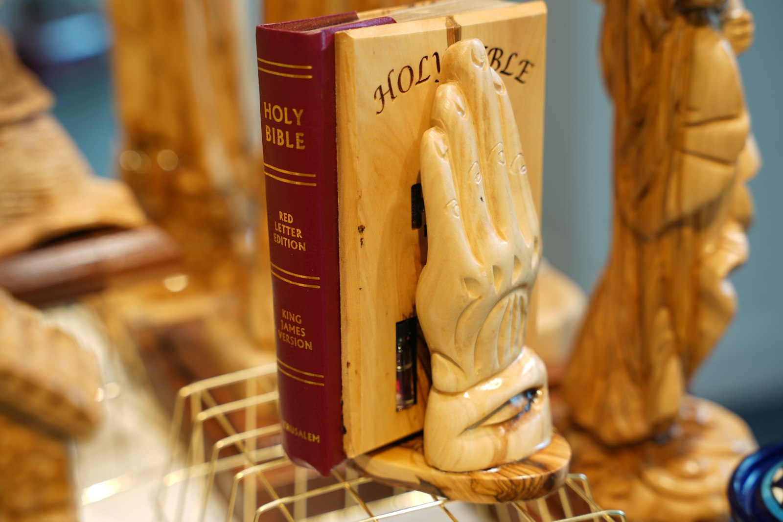 The Lord's hands holding the Bible, one of many hand-carved, olive-wood pieces created by 52 families in the Bethlehem area that are on sale at Jerusalem Arts, a storefront at Great Lakes Crossing Outlet Mall in Auburn Hills. The store, owned by Husam Khair, supports the Christian community in the Holy Land with proceeds from the store's sales.